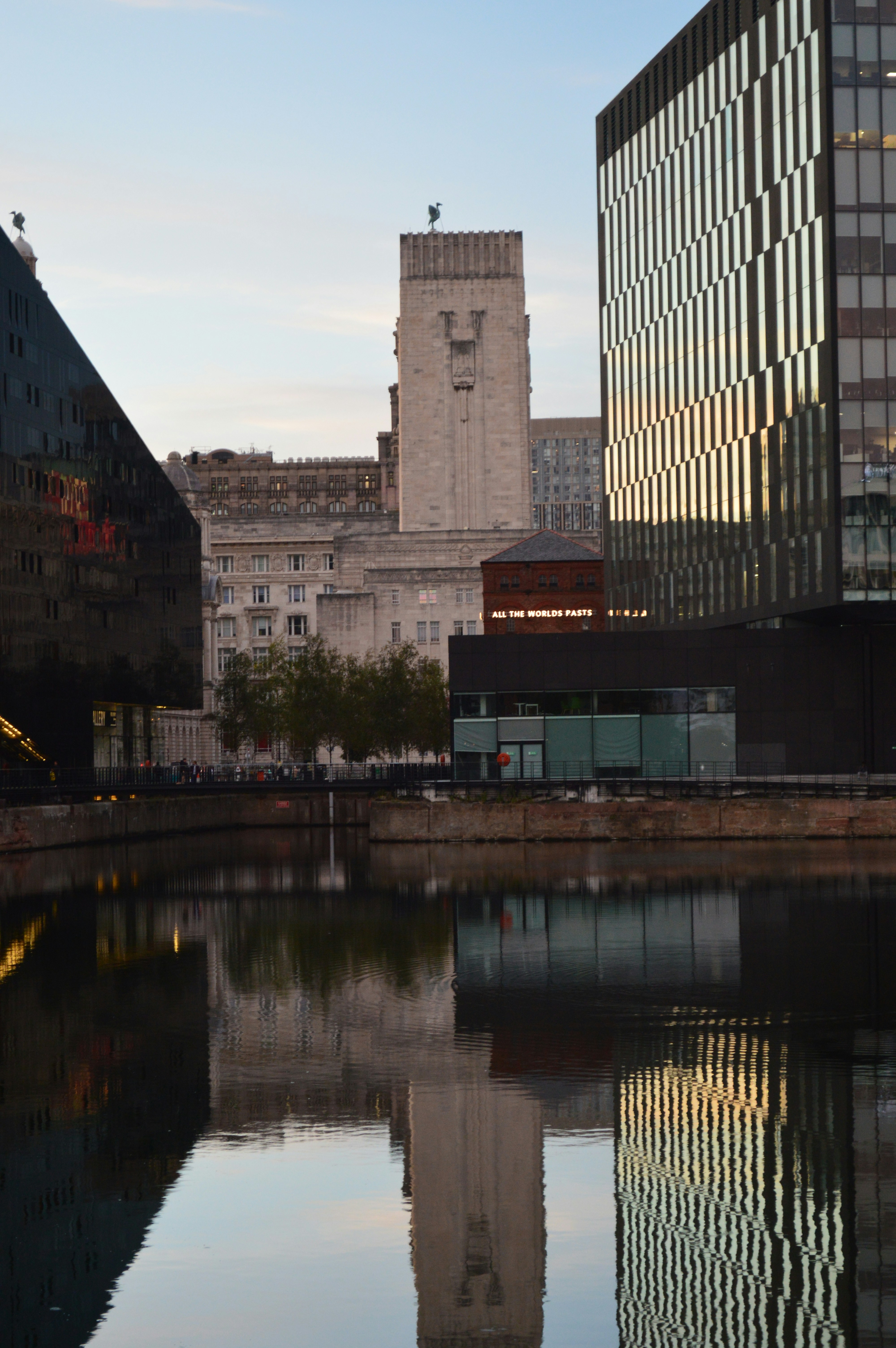 Modern and historic buildings reflected in the calm water of the Liverpool docks