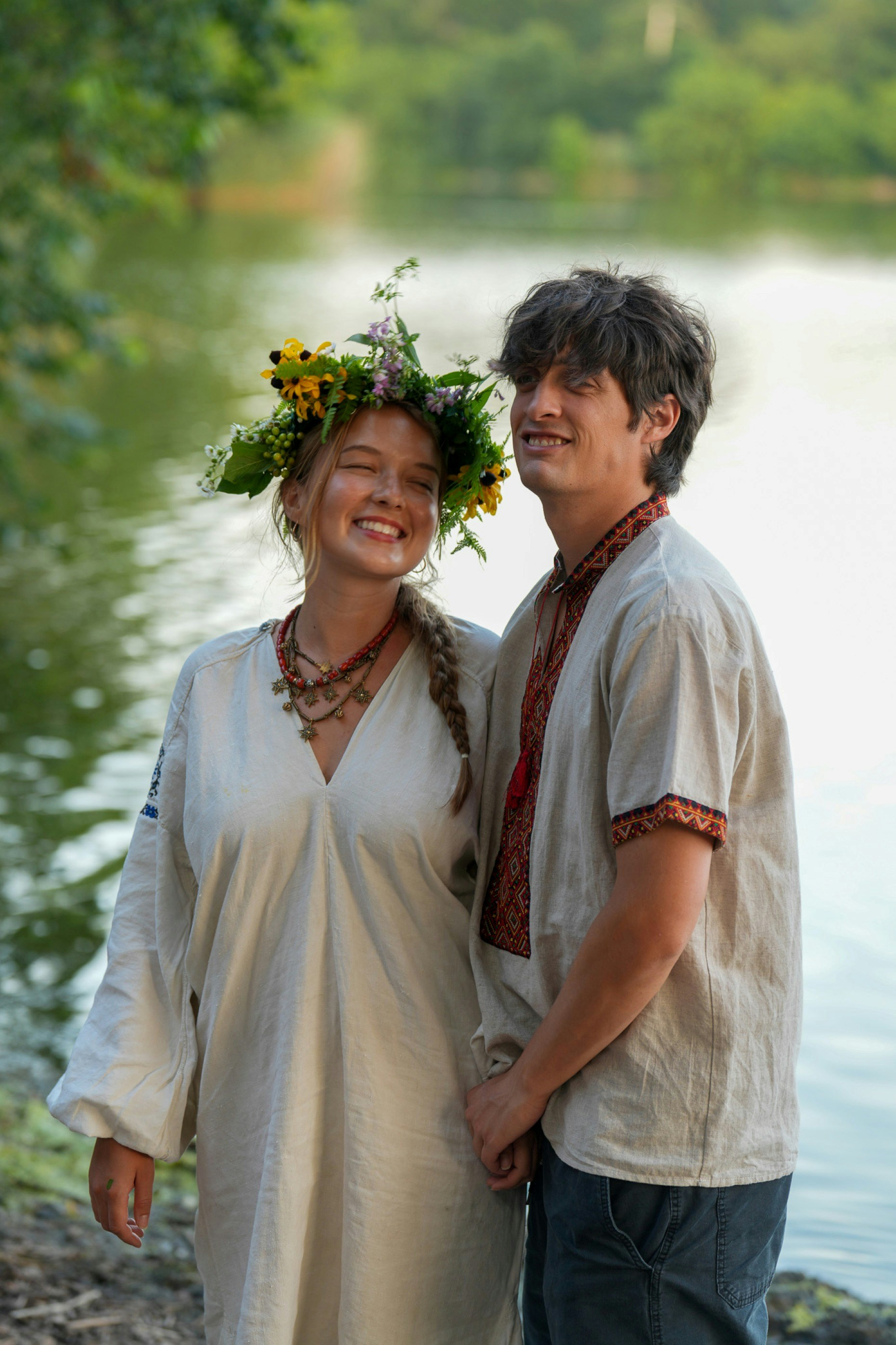 A woman wearing a flower crown and a man in traditional embroidered shirts