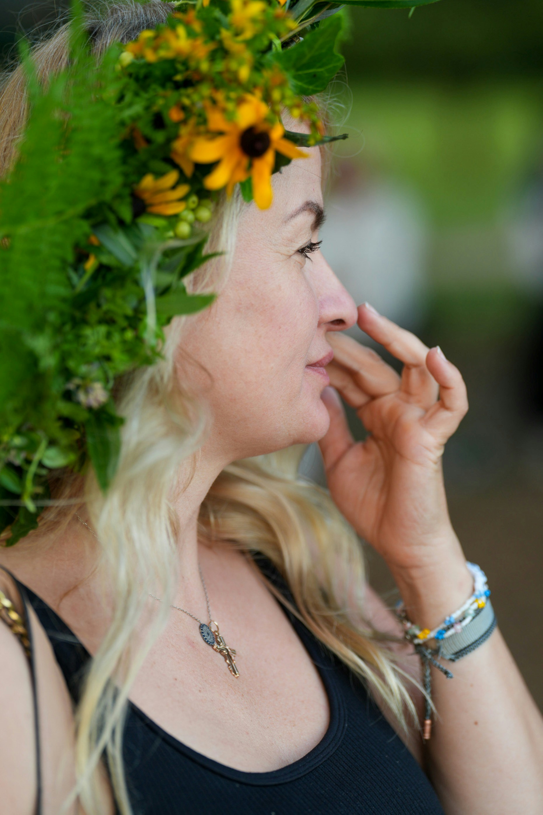 A woman wearing a floral crown of yellow flowers and green leaves