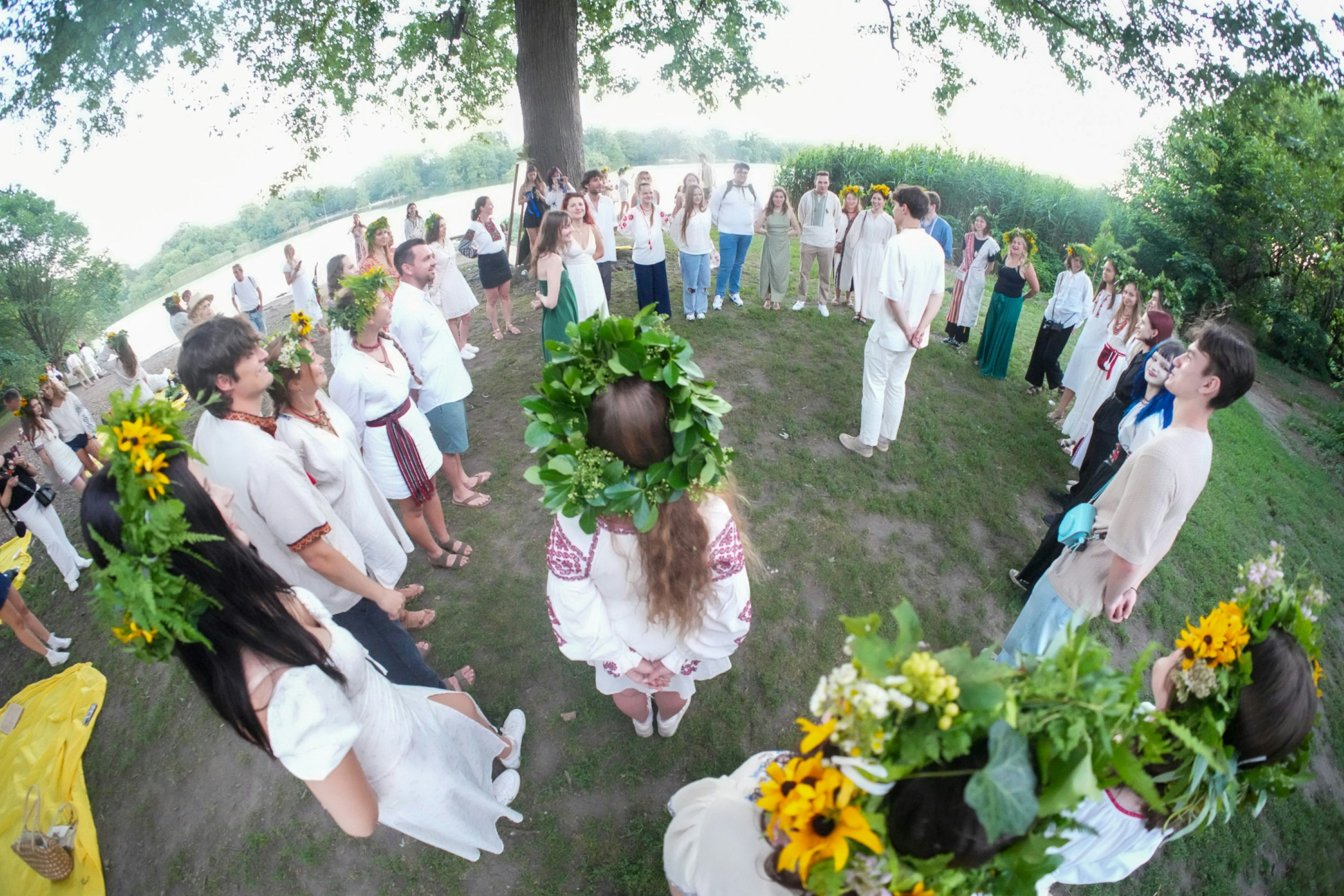 A large group of people in traditional clothing standing in a circle outdoors