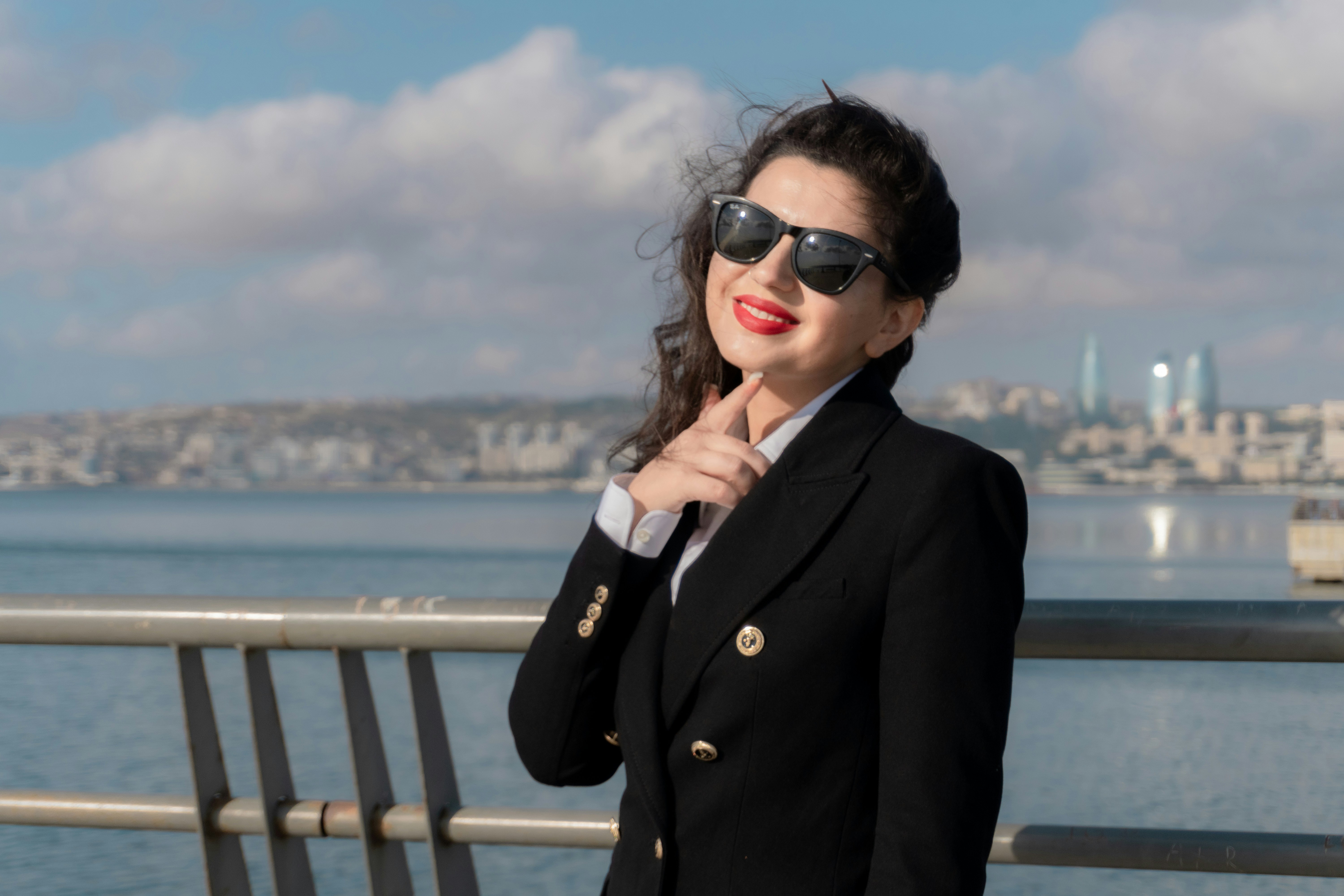 A woman in a black blazer and sunglasses by the sea in Baku
