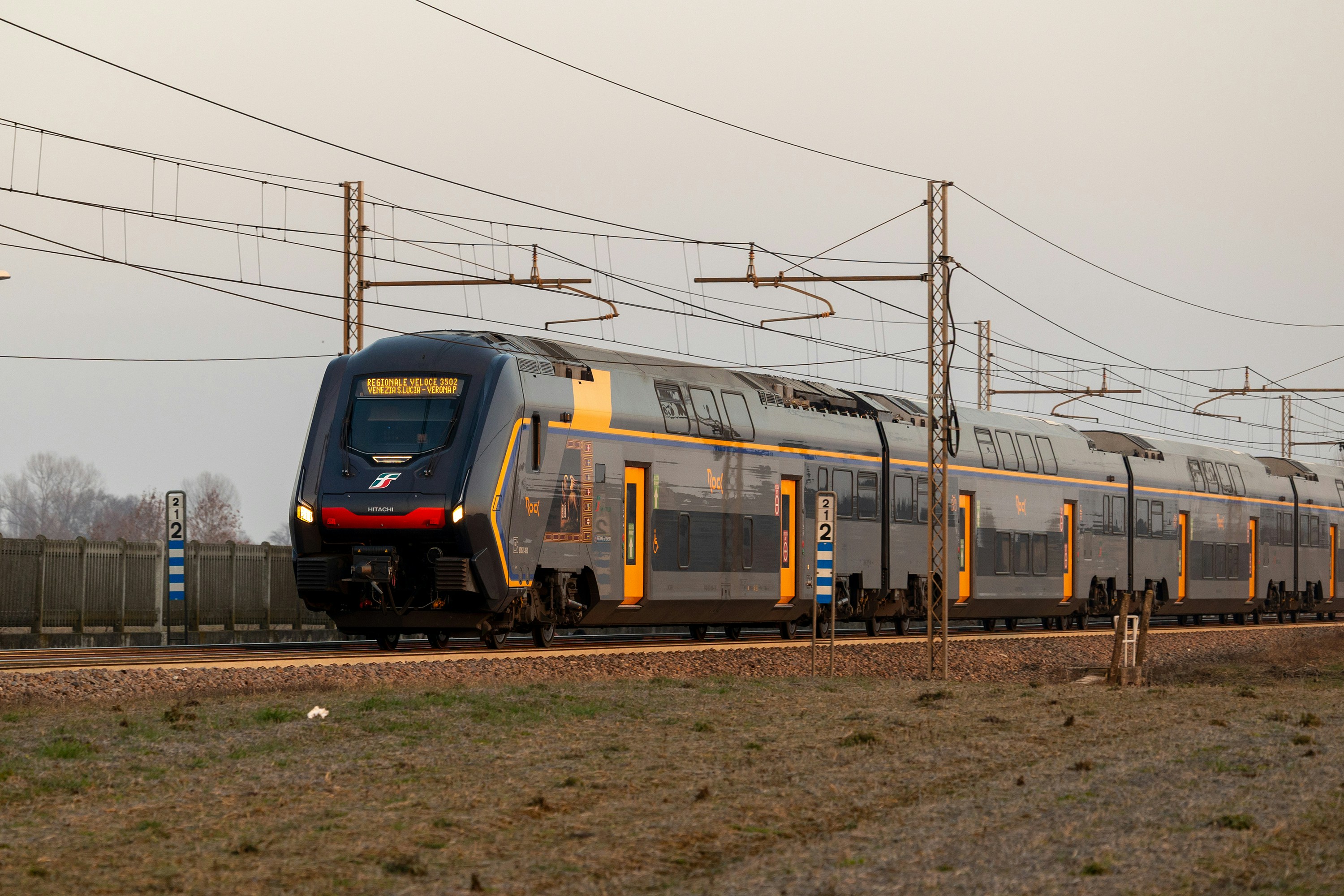 Double-decker passenger train crossing open country