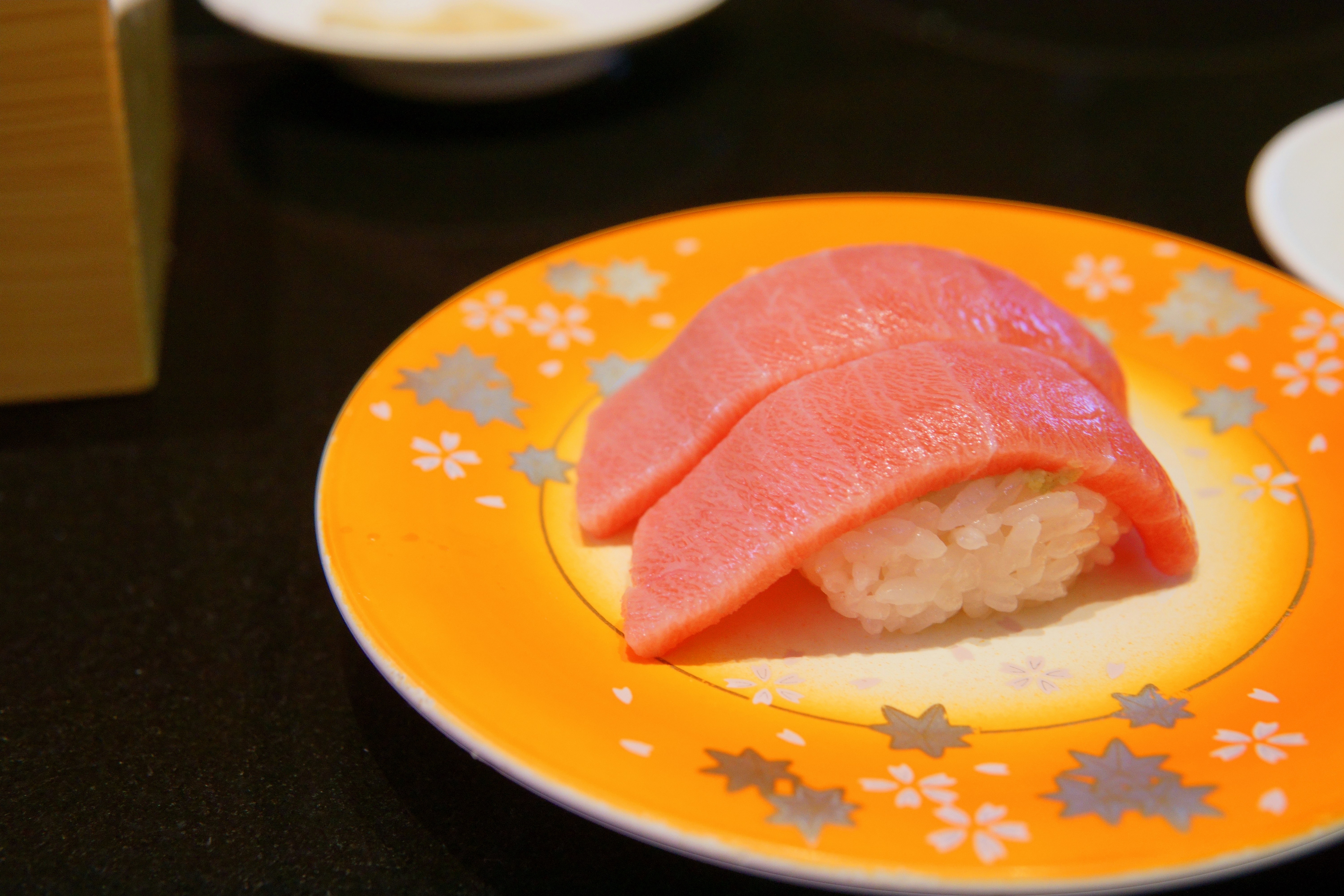 Tuna nigiri on an orange plate