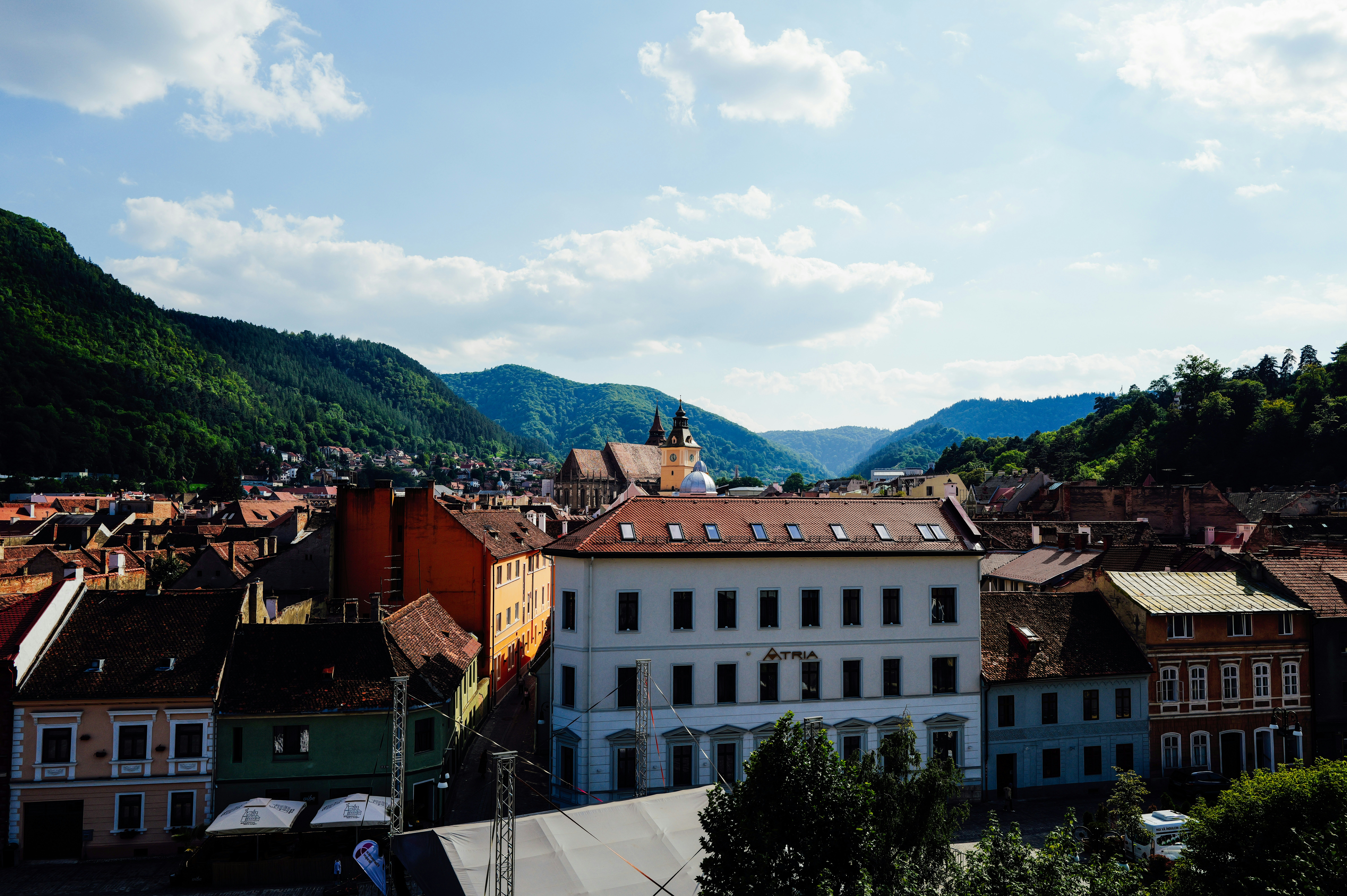 A view of the historic town of Brasov nestled among green mountains in Romania