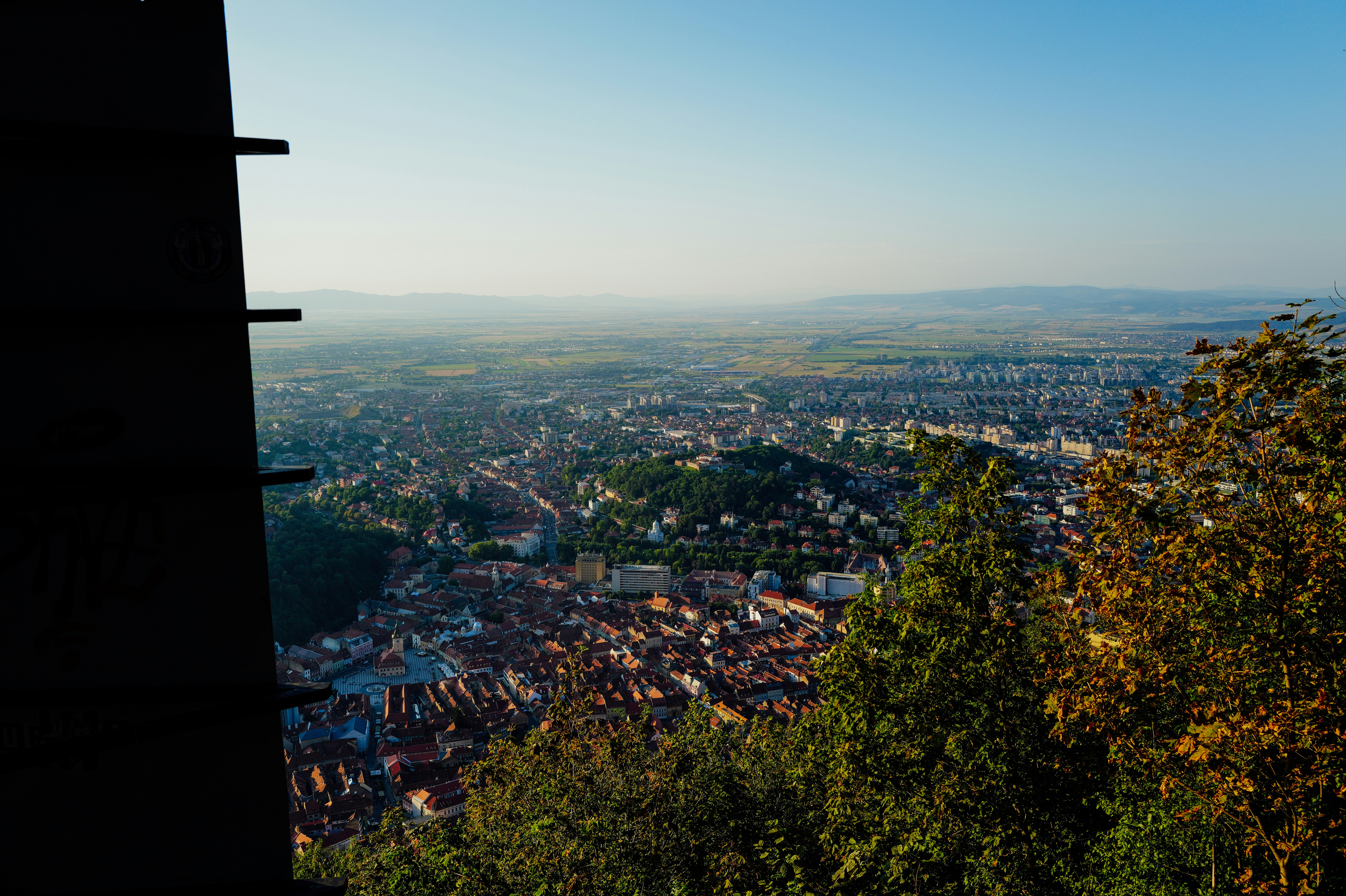 Vista aérea de la ciudad de Brasov con tejados rojos y colinas verdes