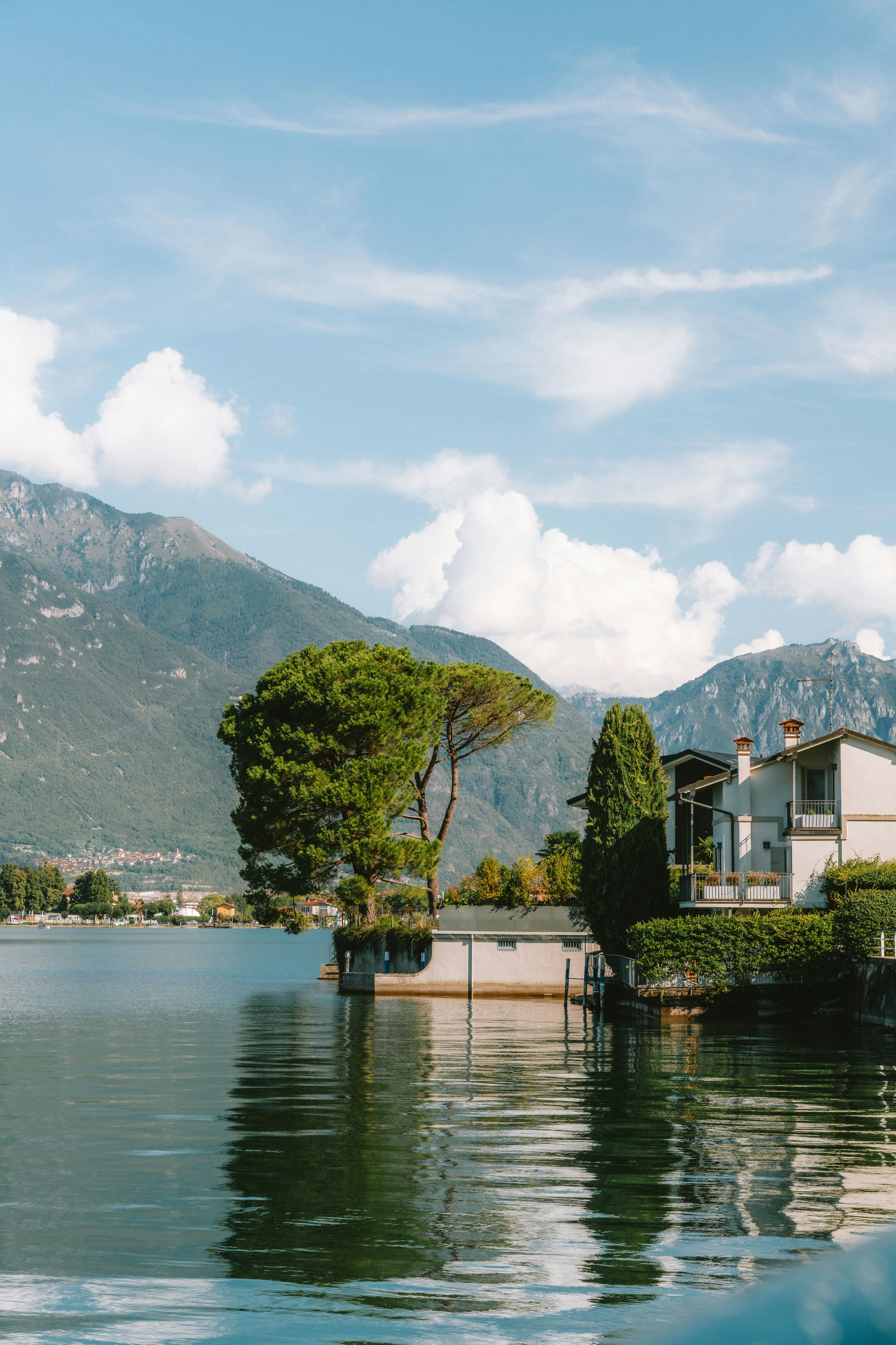 Une maison au bord d’un lac avec des montagnes en arrière-plan