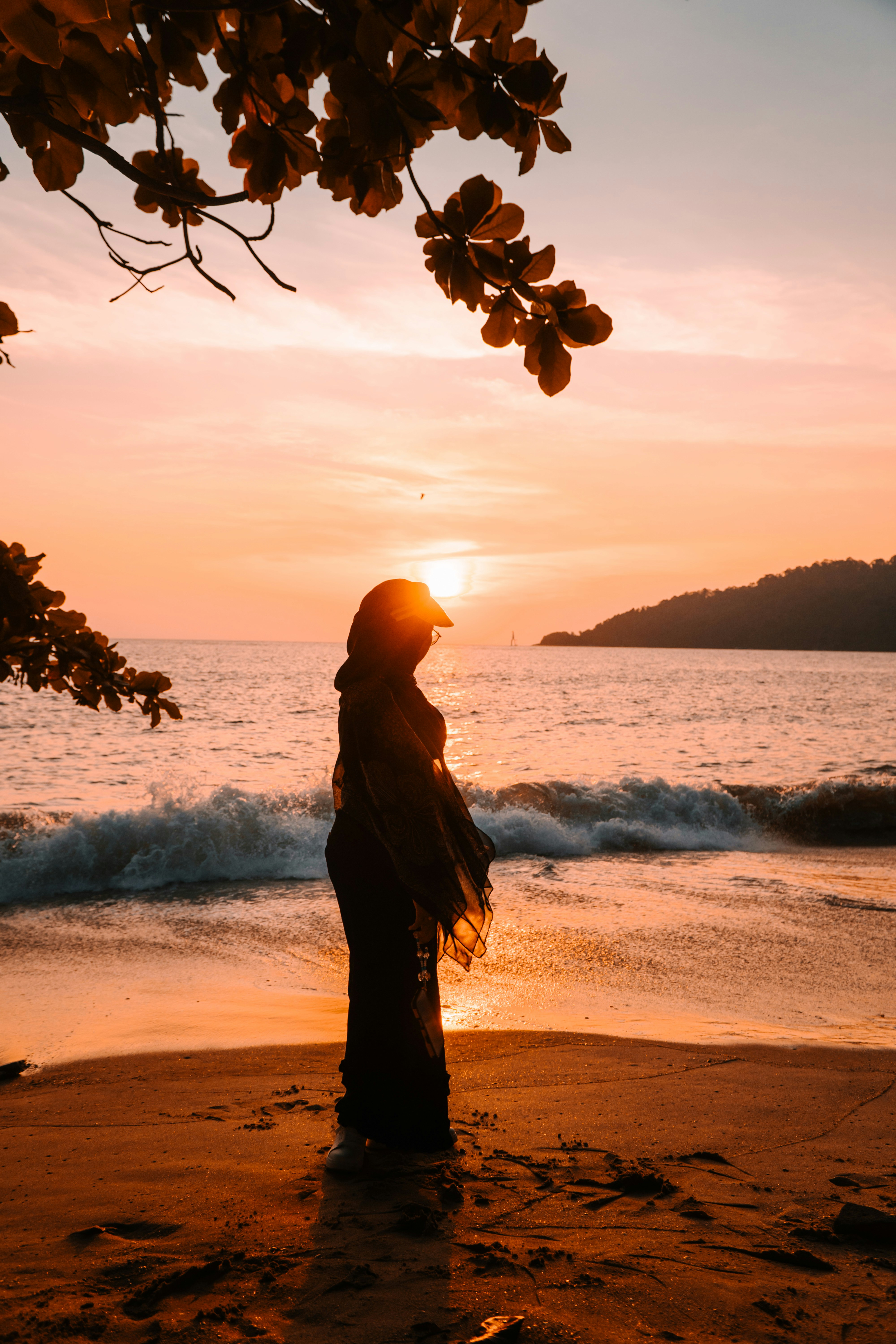 A person in silhouette on a sandy beach during golden hour
