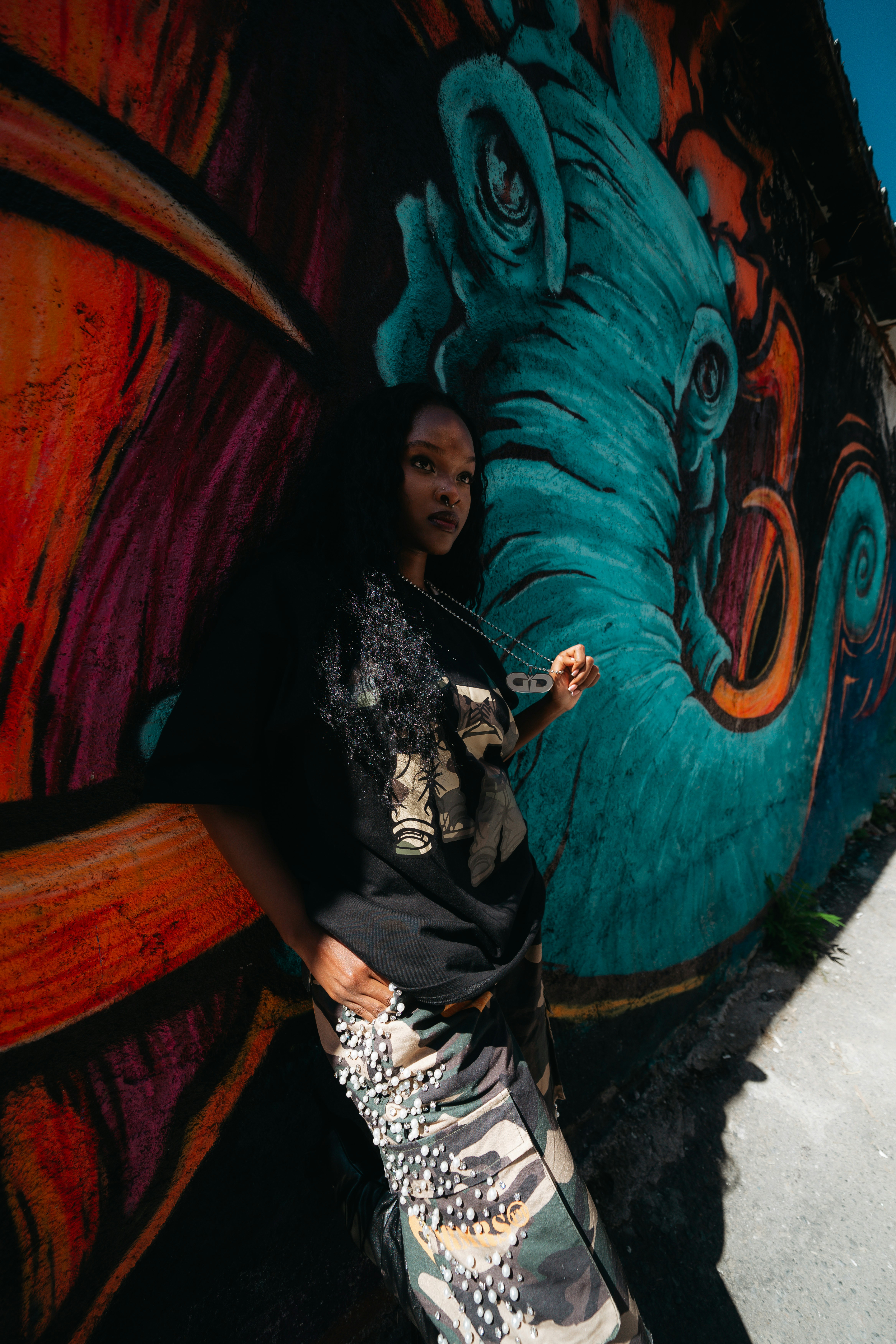 Woman in camouflage pants against graffiti - Free Photo on Unsplash