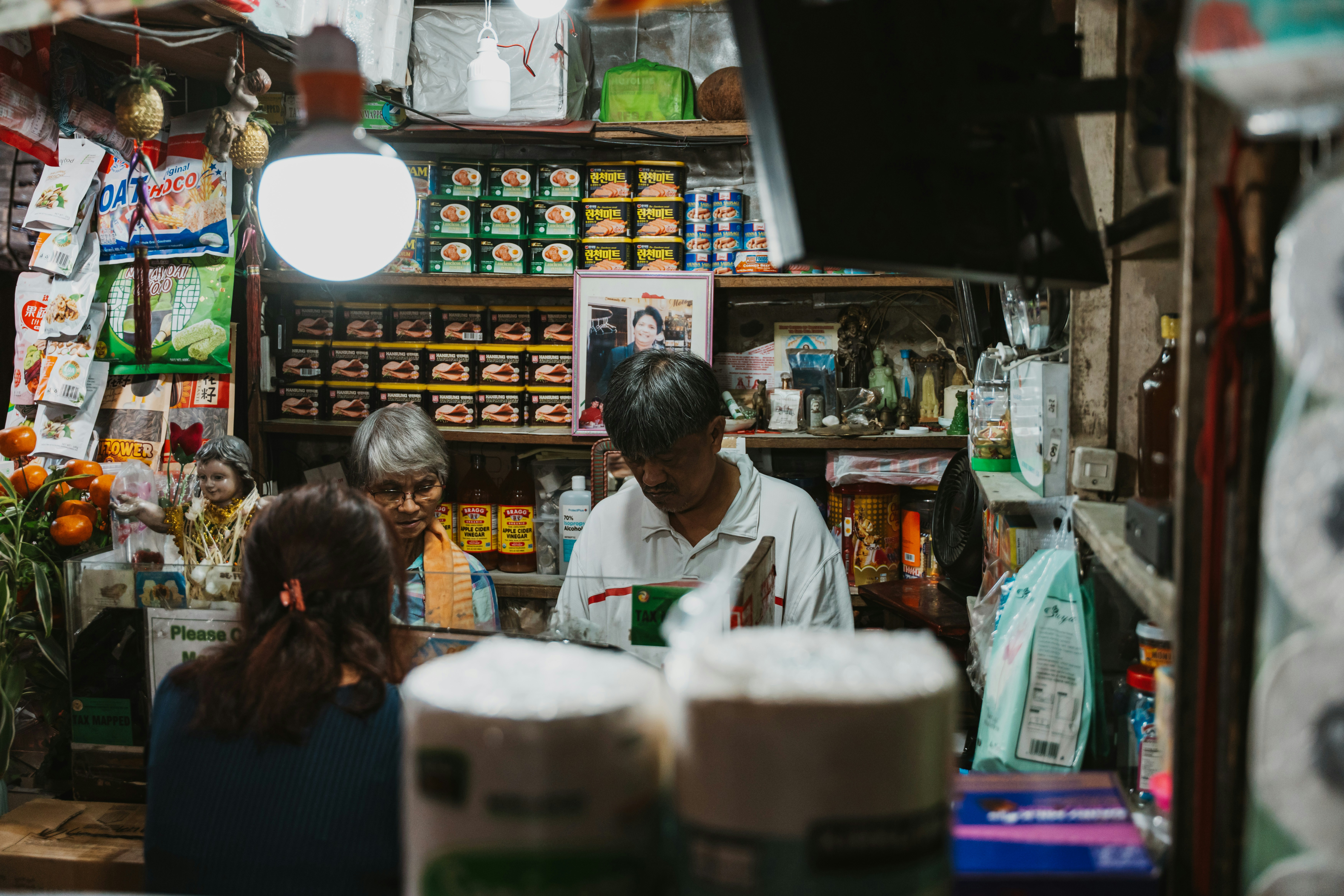 Shopkeepers working behind a crowded store counter
