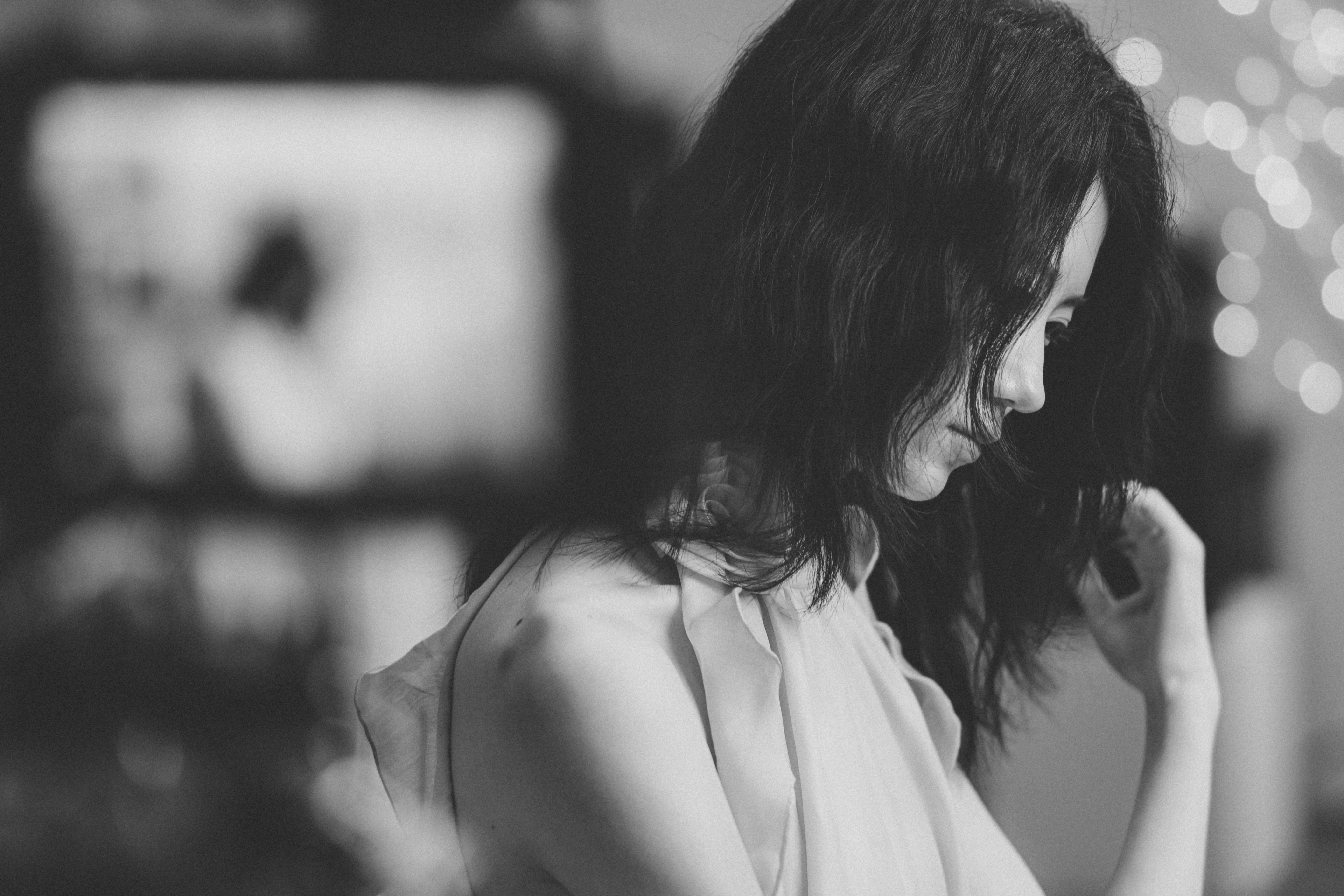 A woman with dark hair in profile against a soft bokeh background