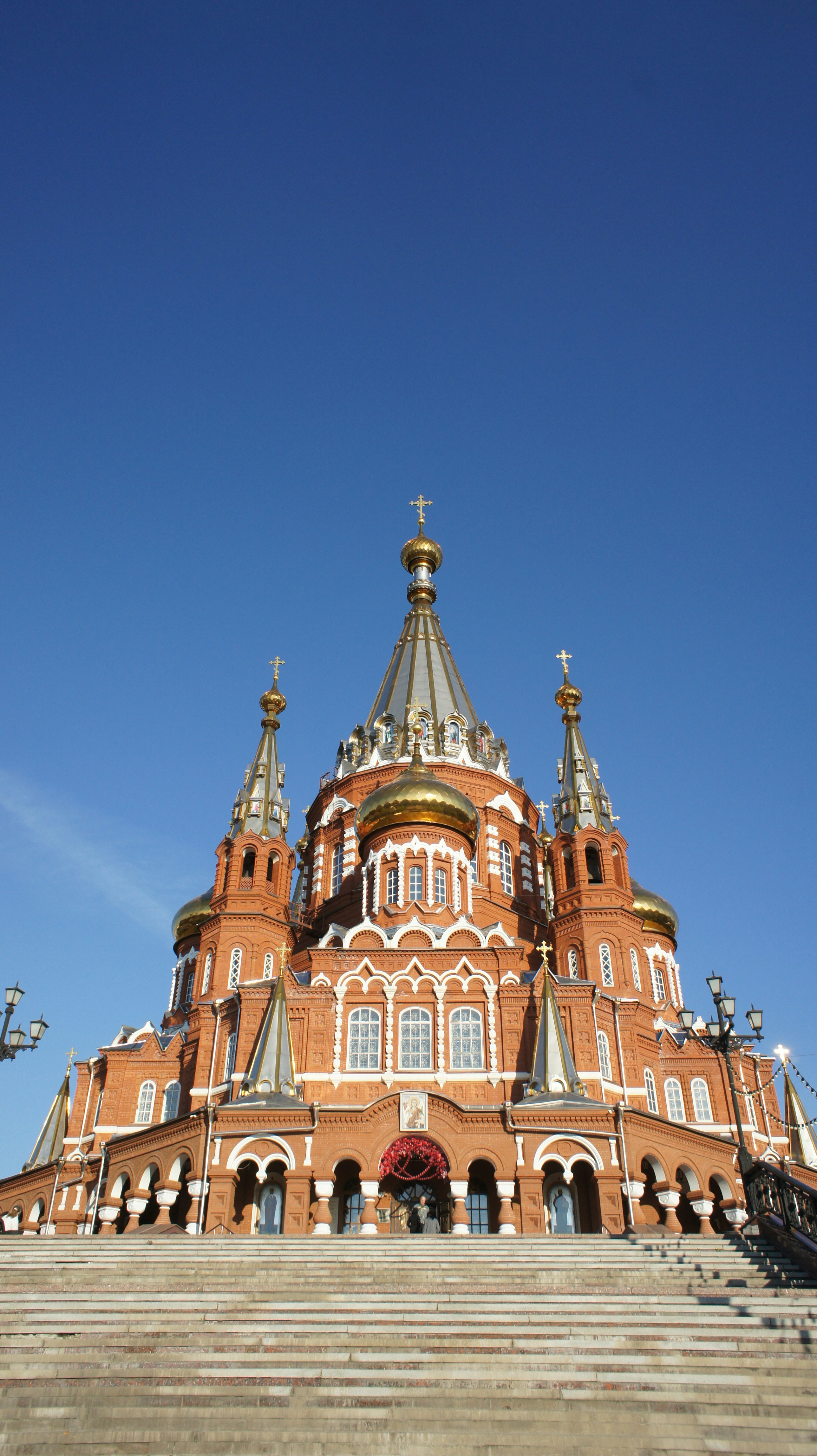 St Michael's Cathedral with red brick walls and golden domes under a clear blue sky