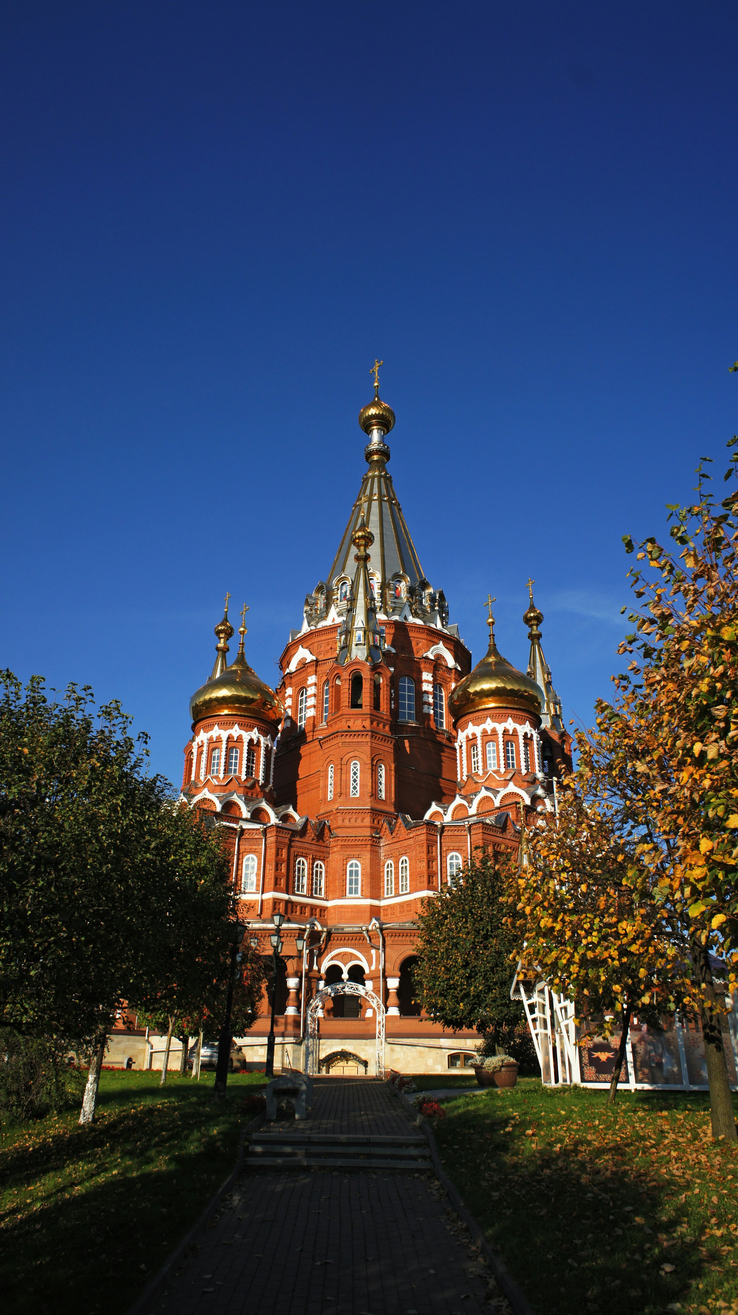 St Michael's Cathedral with golden domes and red brick walls under a clear blue sky