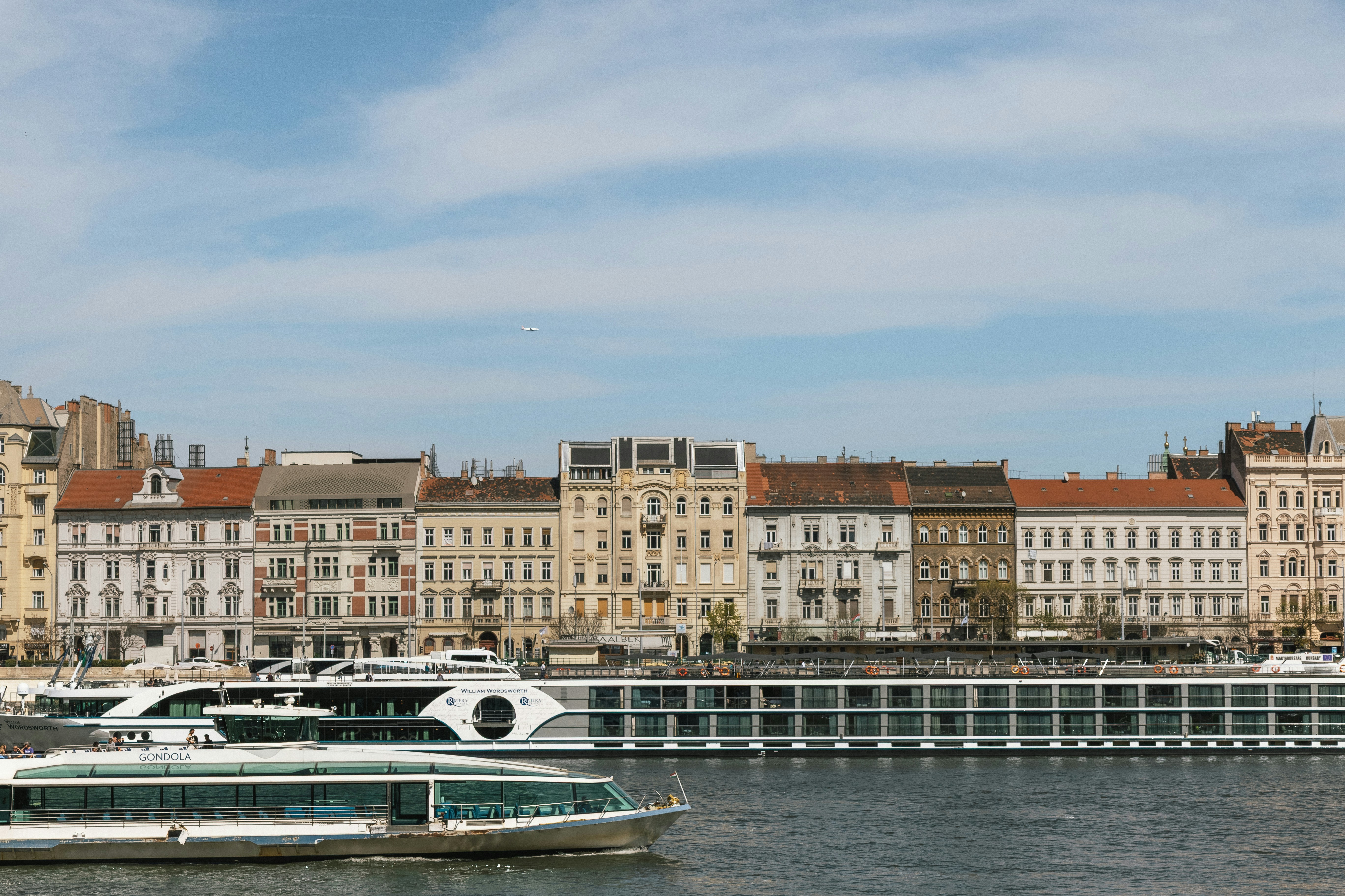 River cruise ships on the Danube river in front of historic buildings in Budapest