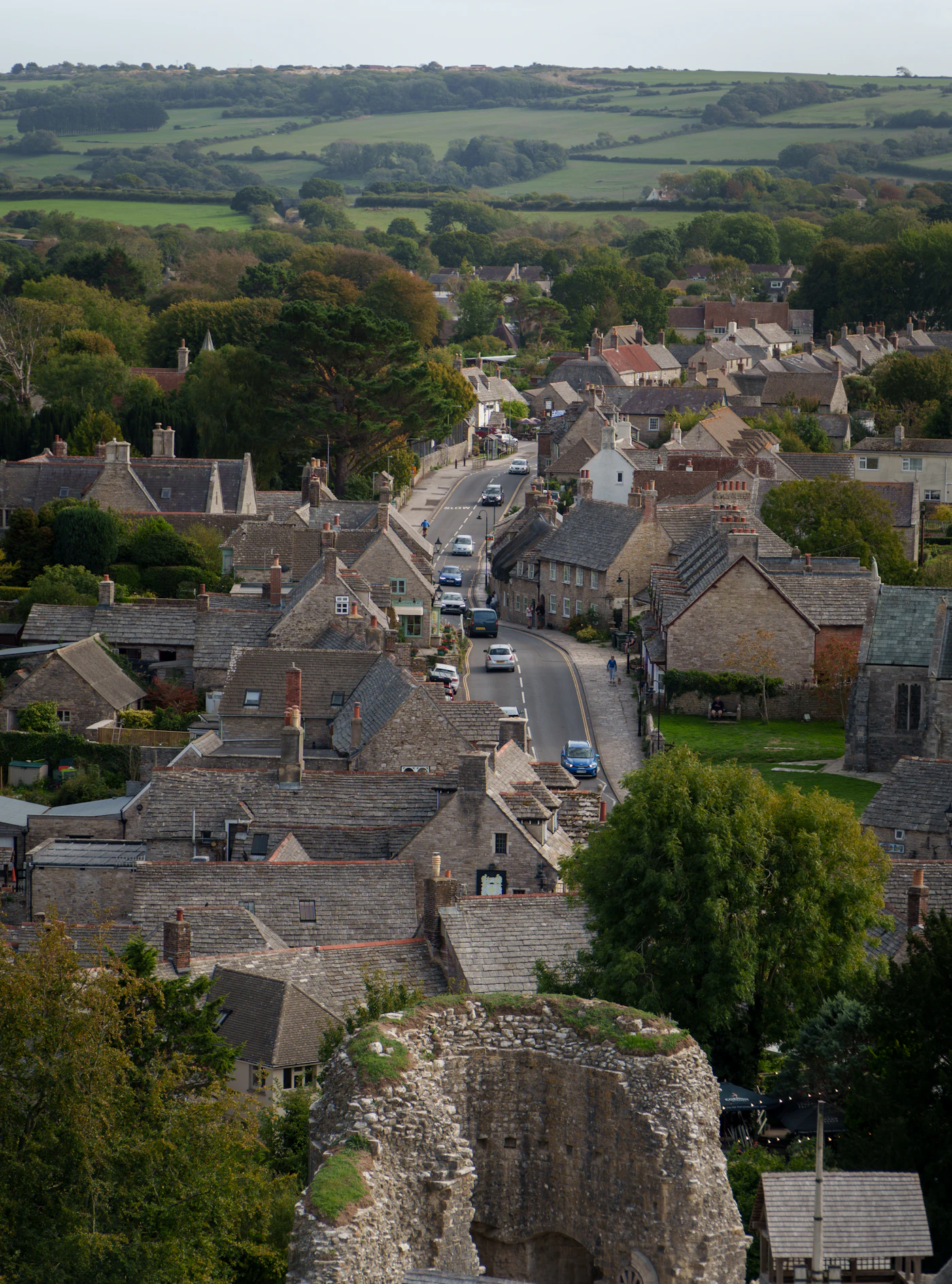 A village of stone houses with rolling green hills beyond