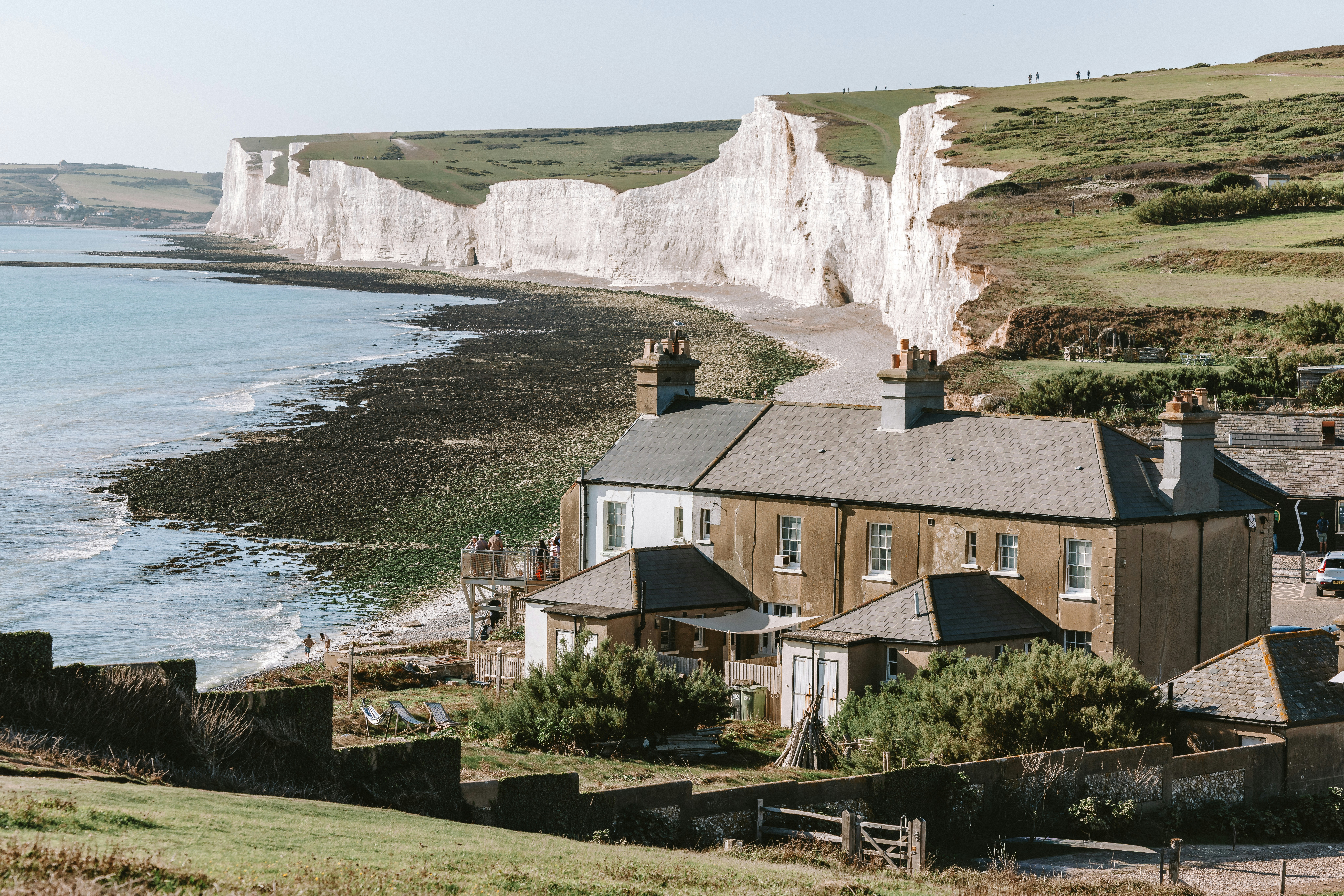A house near white chalk cliffs overlooking the sea in Birling Gap