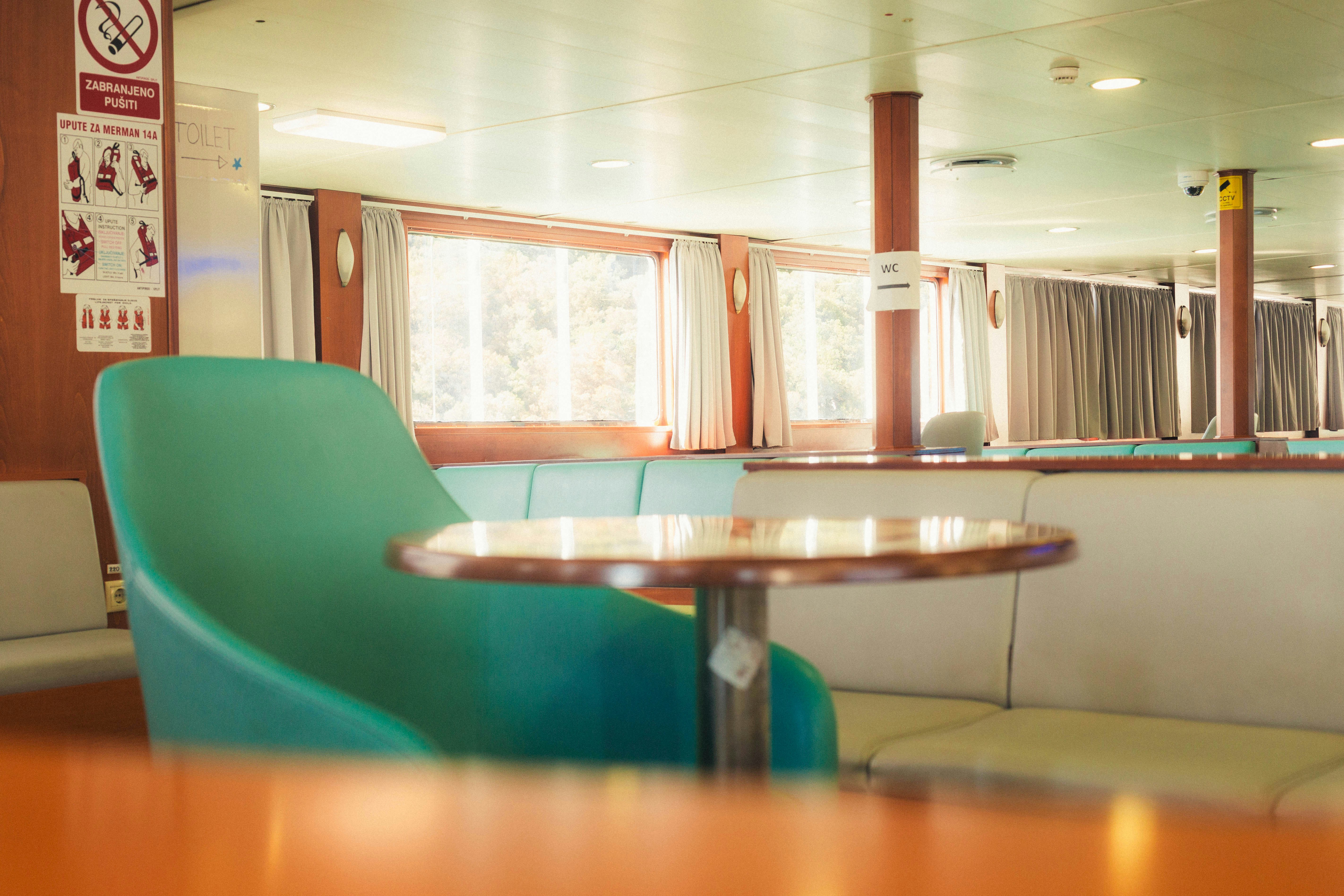 A teal armchair and a small round table in a ferry passenger lounge