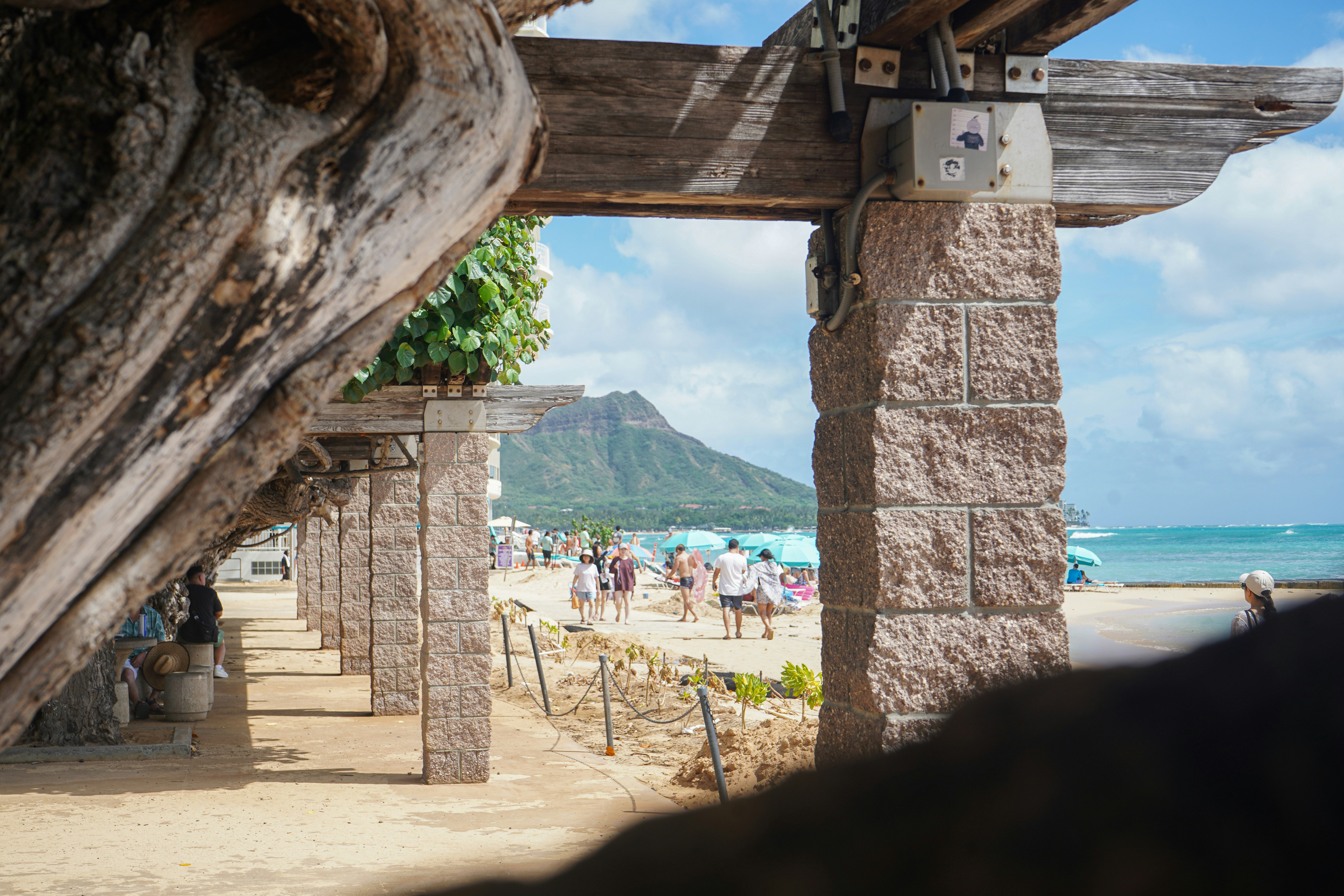 People walking on a sandy beach near Diamond Head in Honolulu, Hawaii
