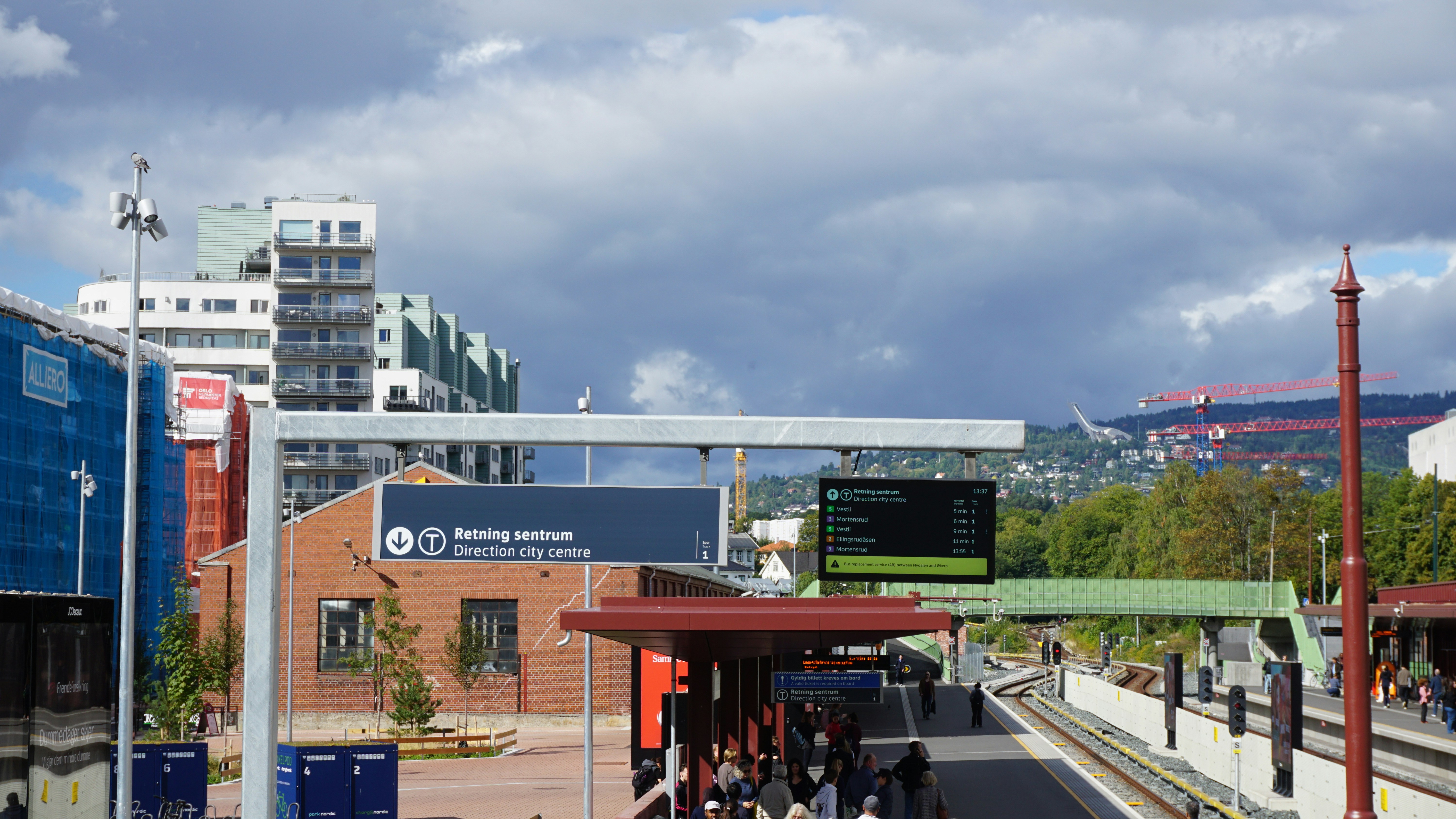 Un andén de metro con un cartel digital de llegada en Oslo, Noruega