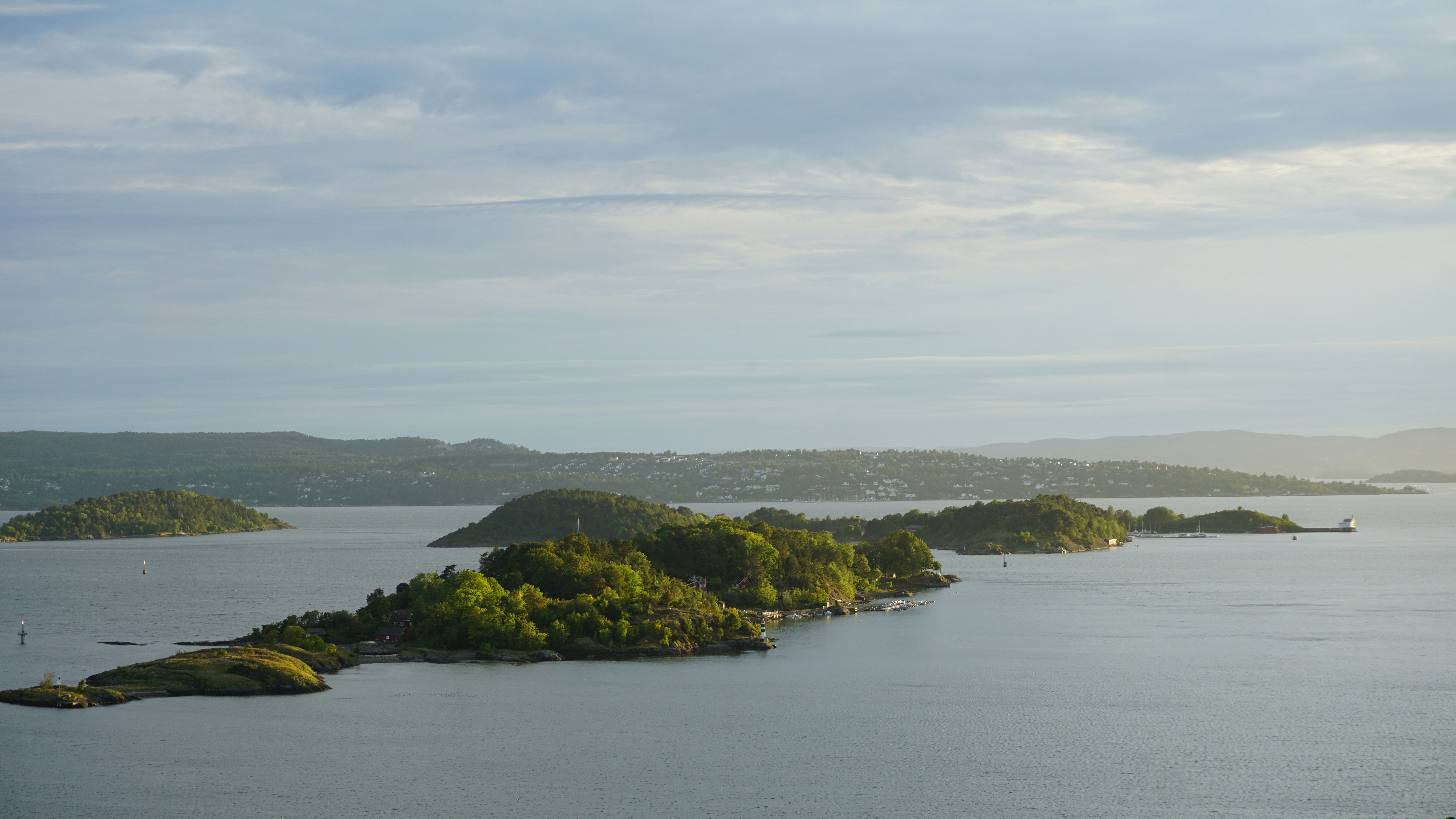 Pequeñas islas verdes en una bahía tranquila bajo un cielo nublado y suave