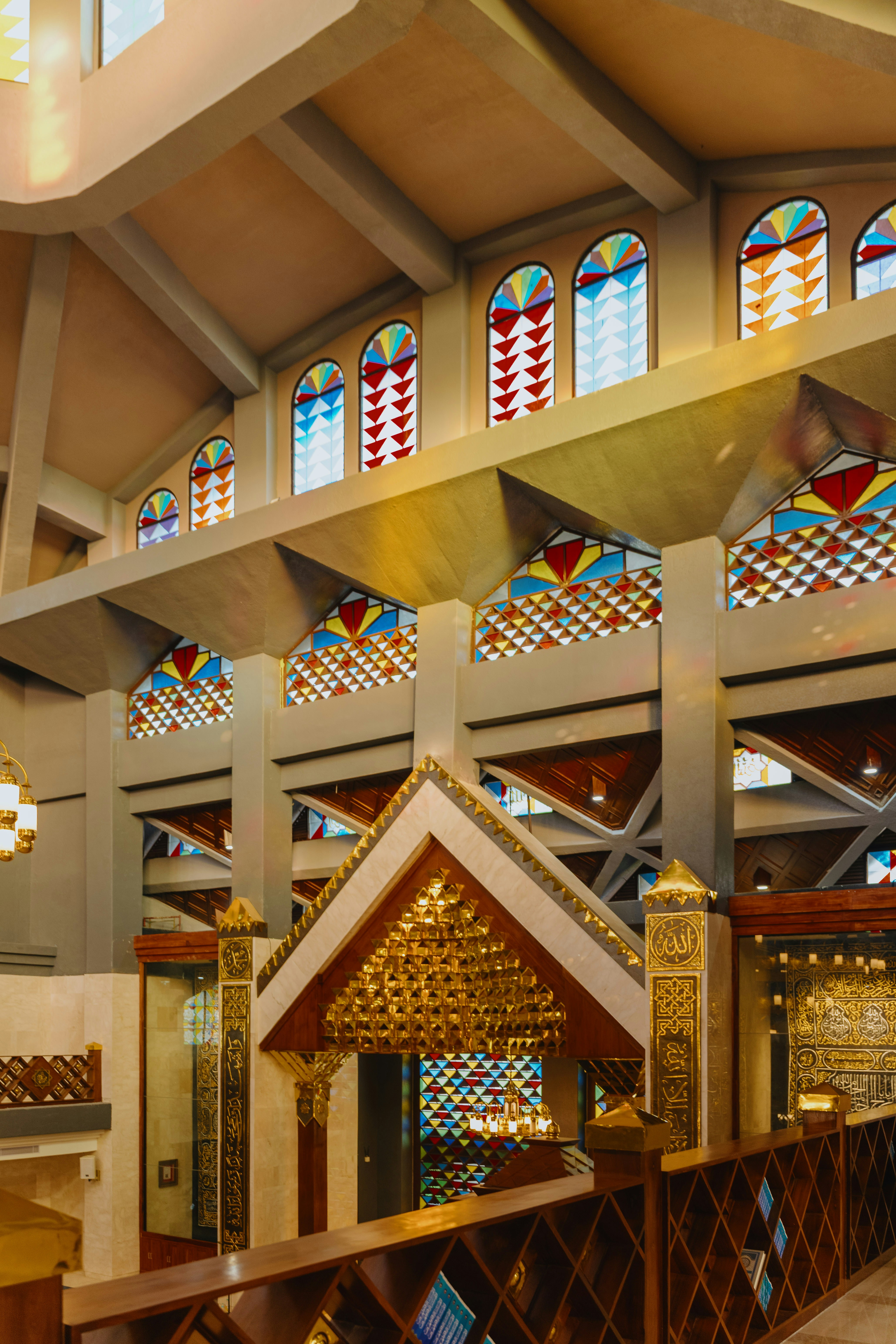Stained glass windows and carved wooden beams inside Masjid Nurul Wathon in Bogor