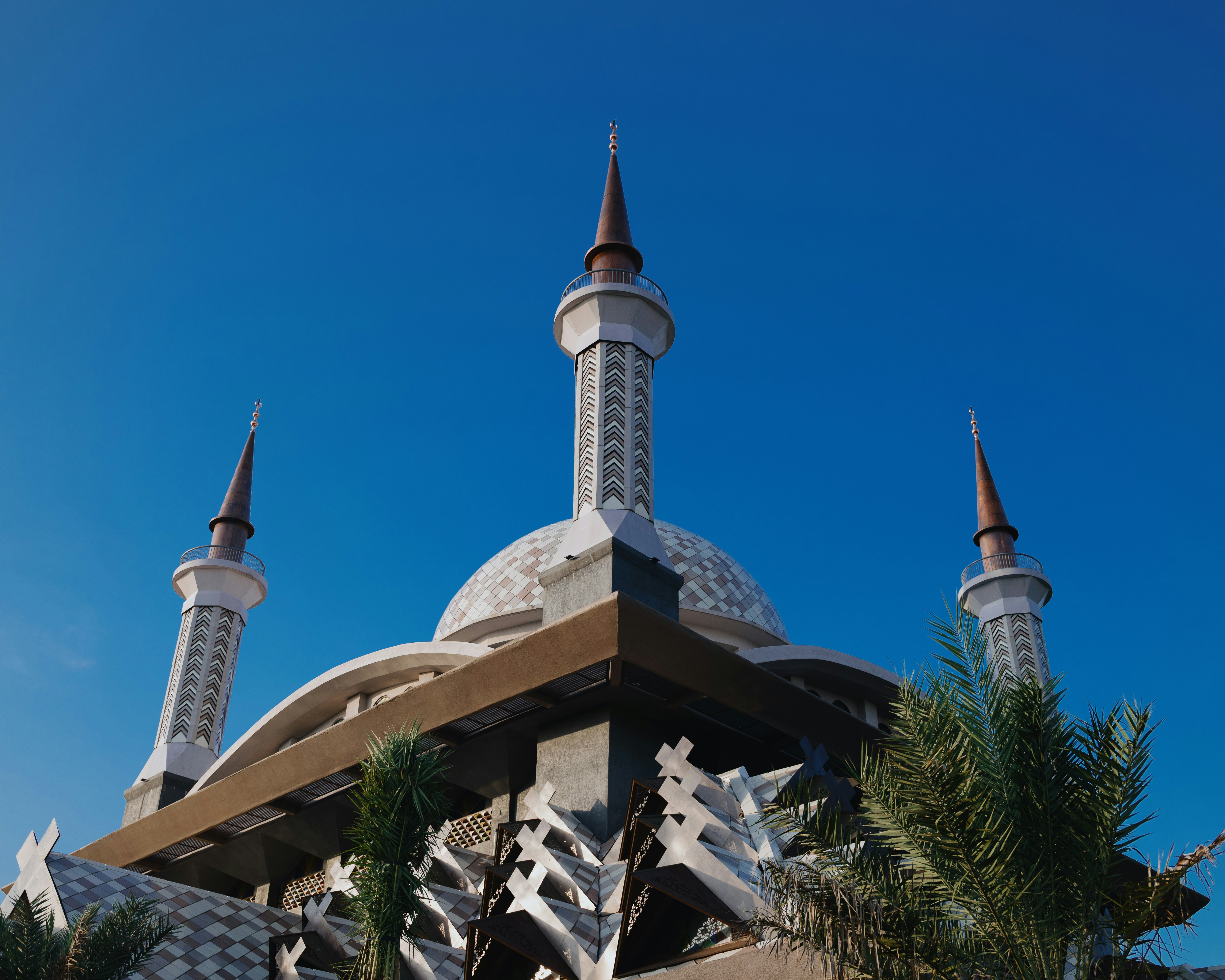 The dome and minarets of Masjid Nurul Wathon against a clear blue sky