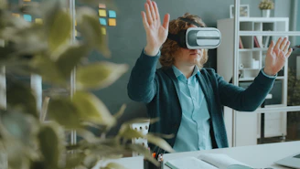 A person with curly hair wearing a virtual reality headset in a workspace