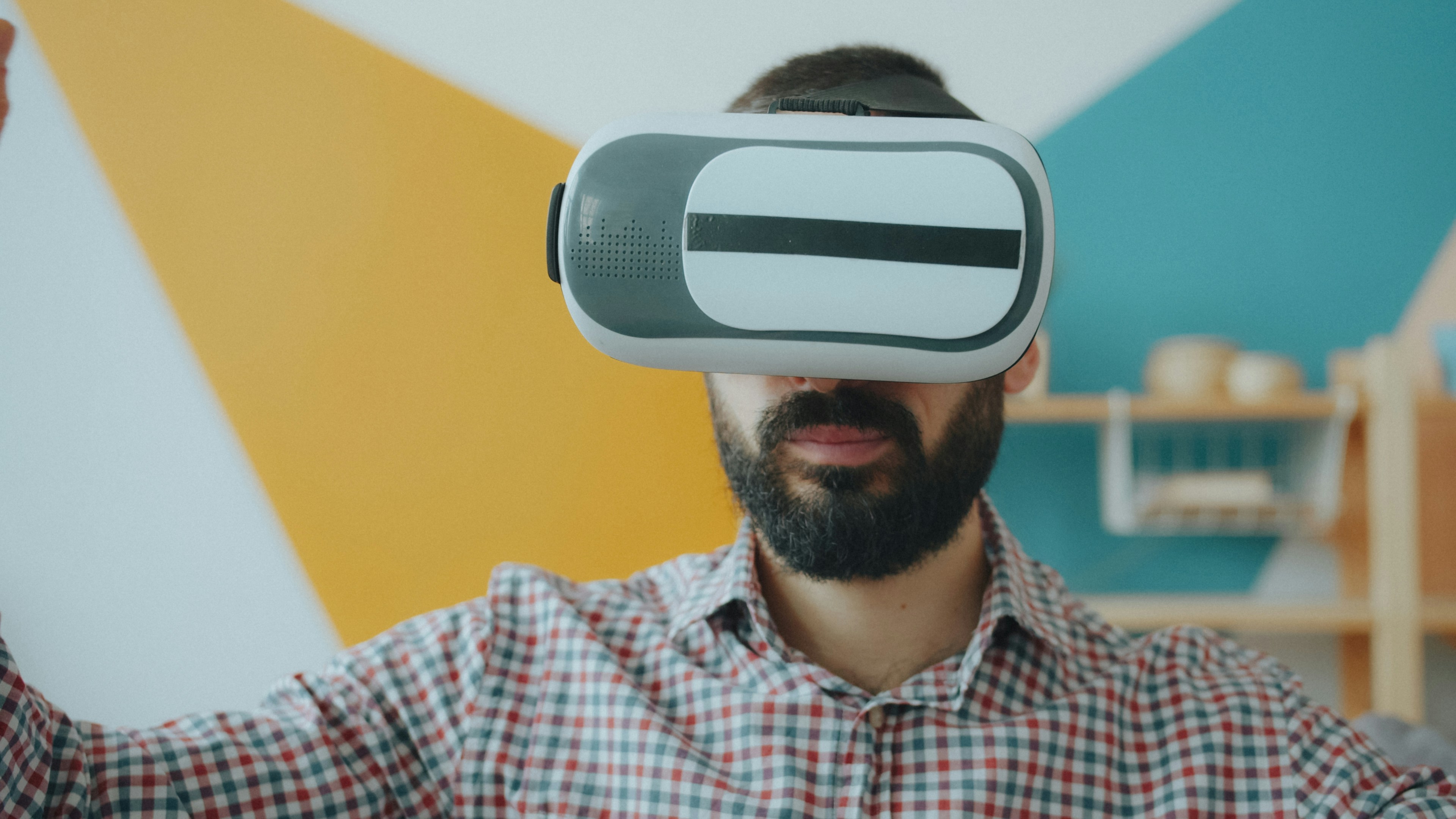 A man with a beard wearing a virtual reality headset in a room