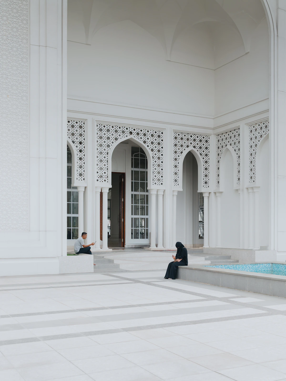 Mihrab putih dengan ukiran di dalam masjid