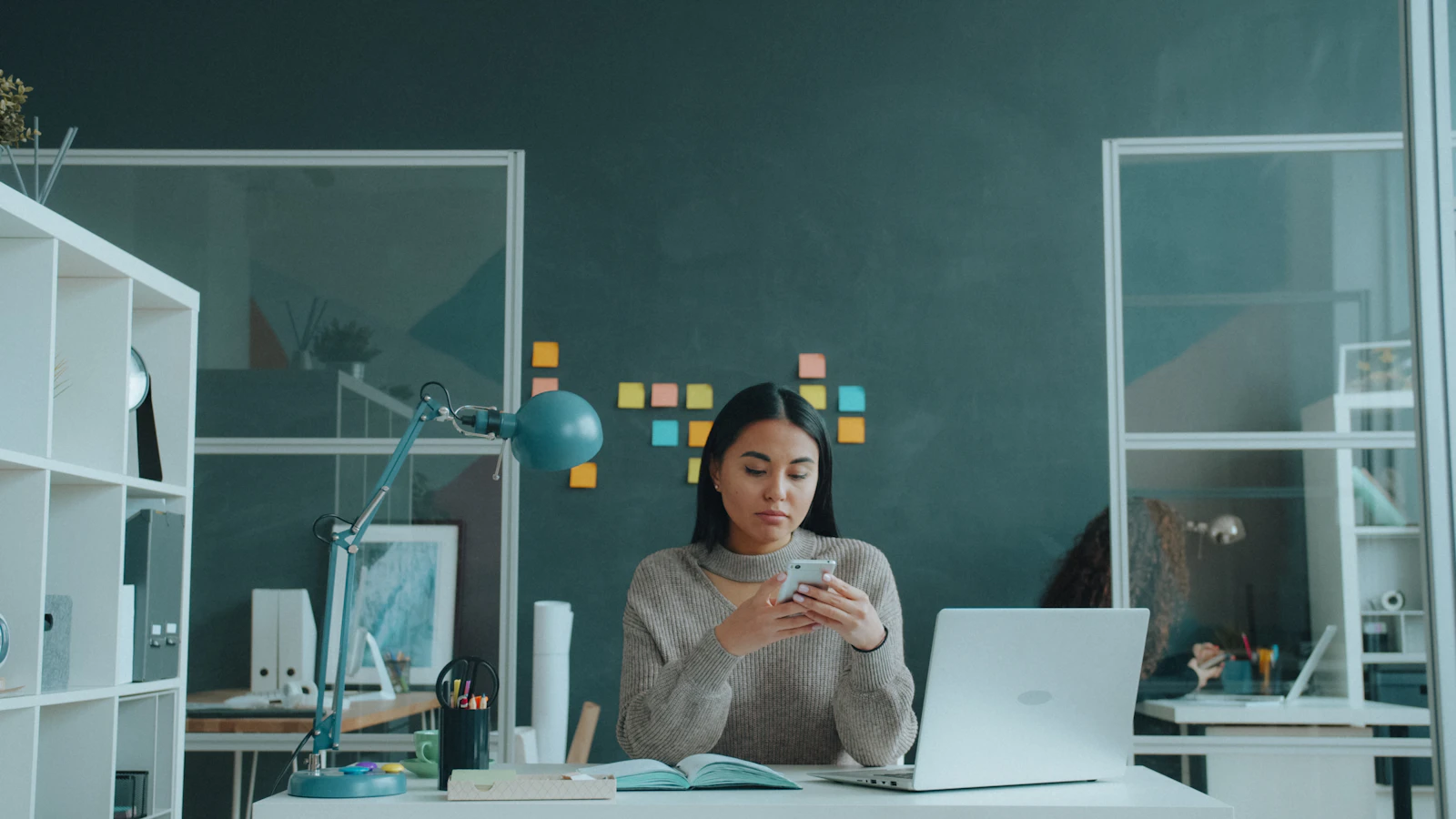 Woman checking her smartphone at a desk