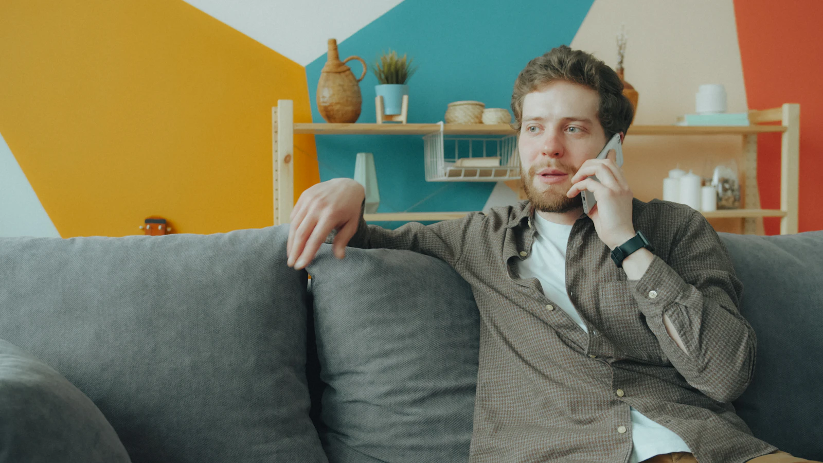 Man talking on his smartphone on a sofa