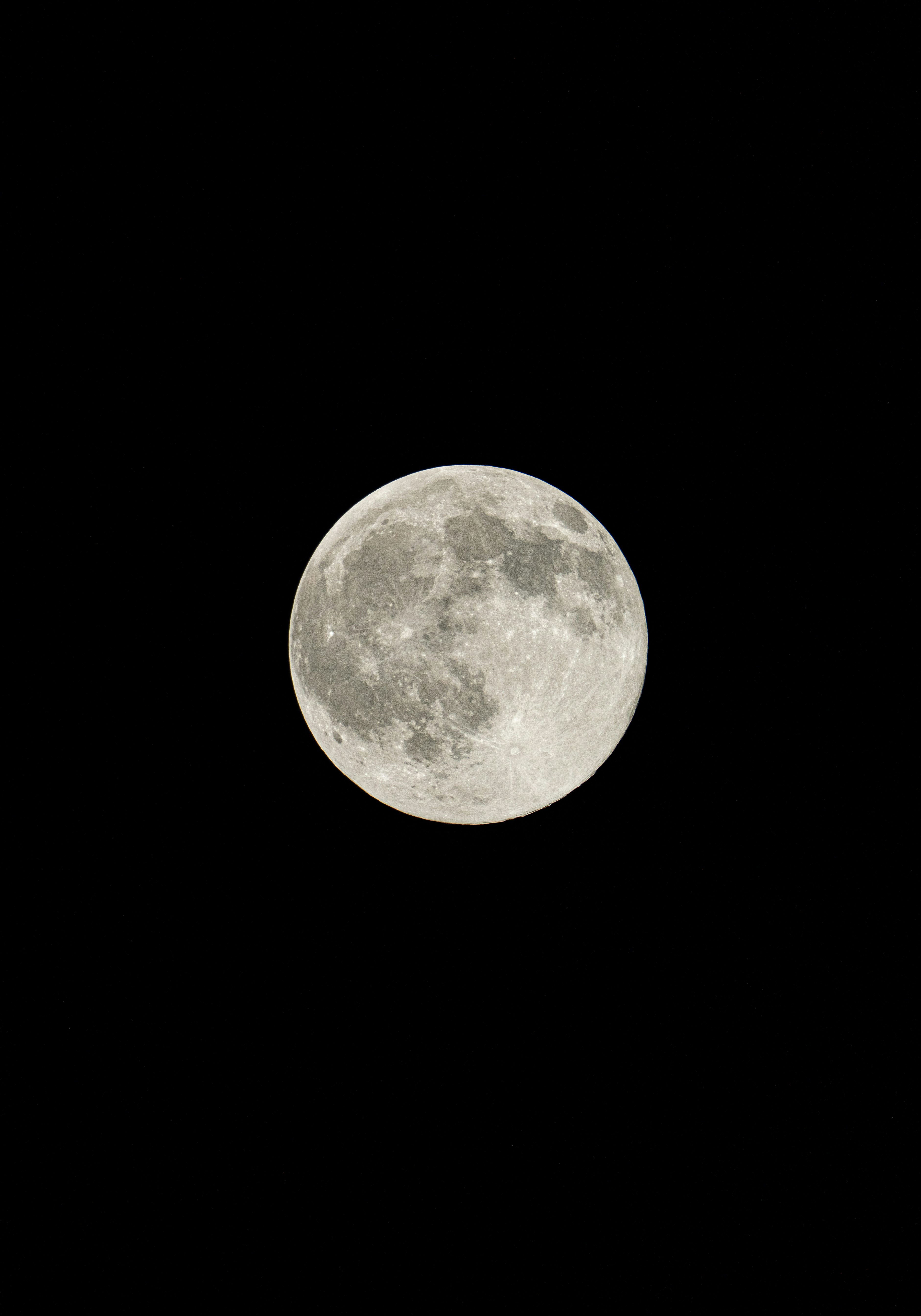 A full moon glowing against a solid black night sky