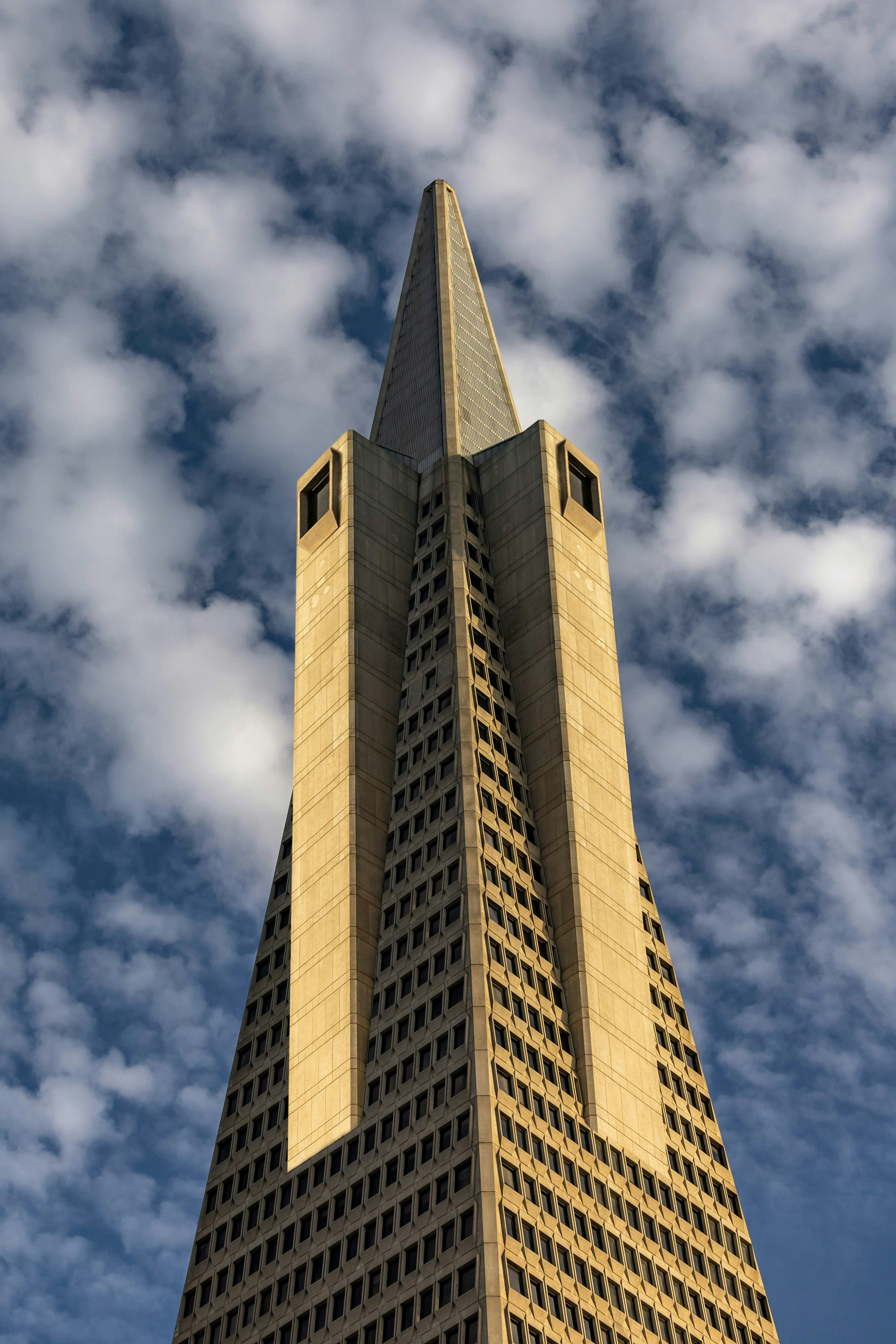 The Transamerica Pyramid skyscraper reaching toward a blue sky with scattered white clouds