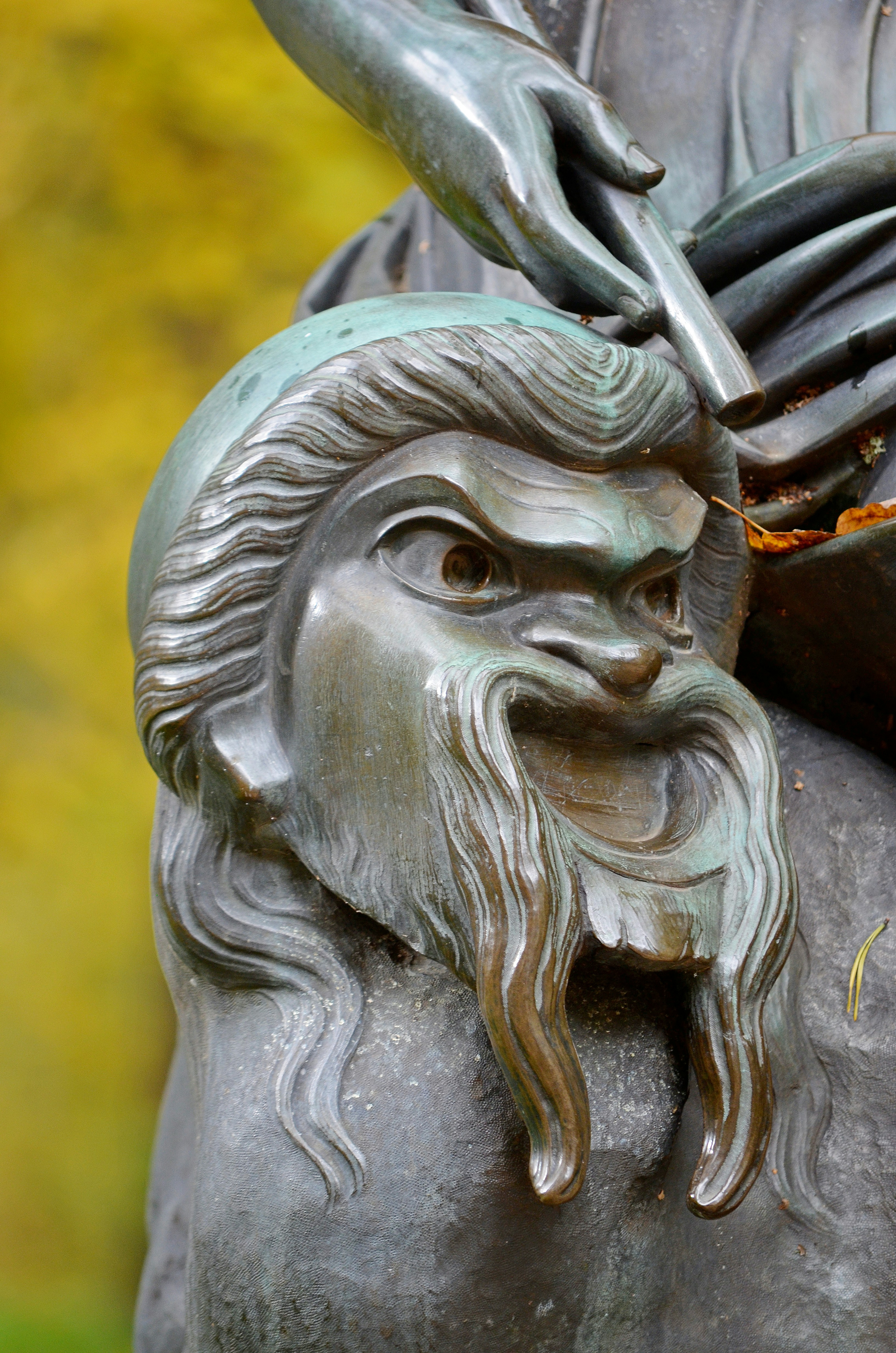 A bronze sculpture of a bearded man with a cap and wide eyes