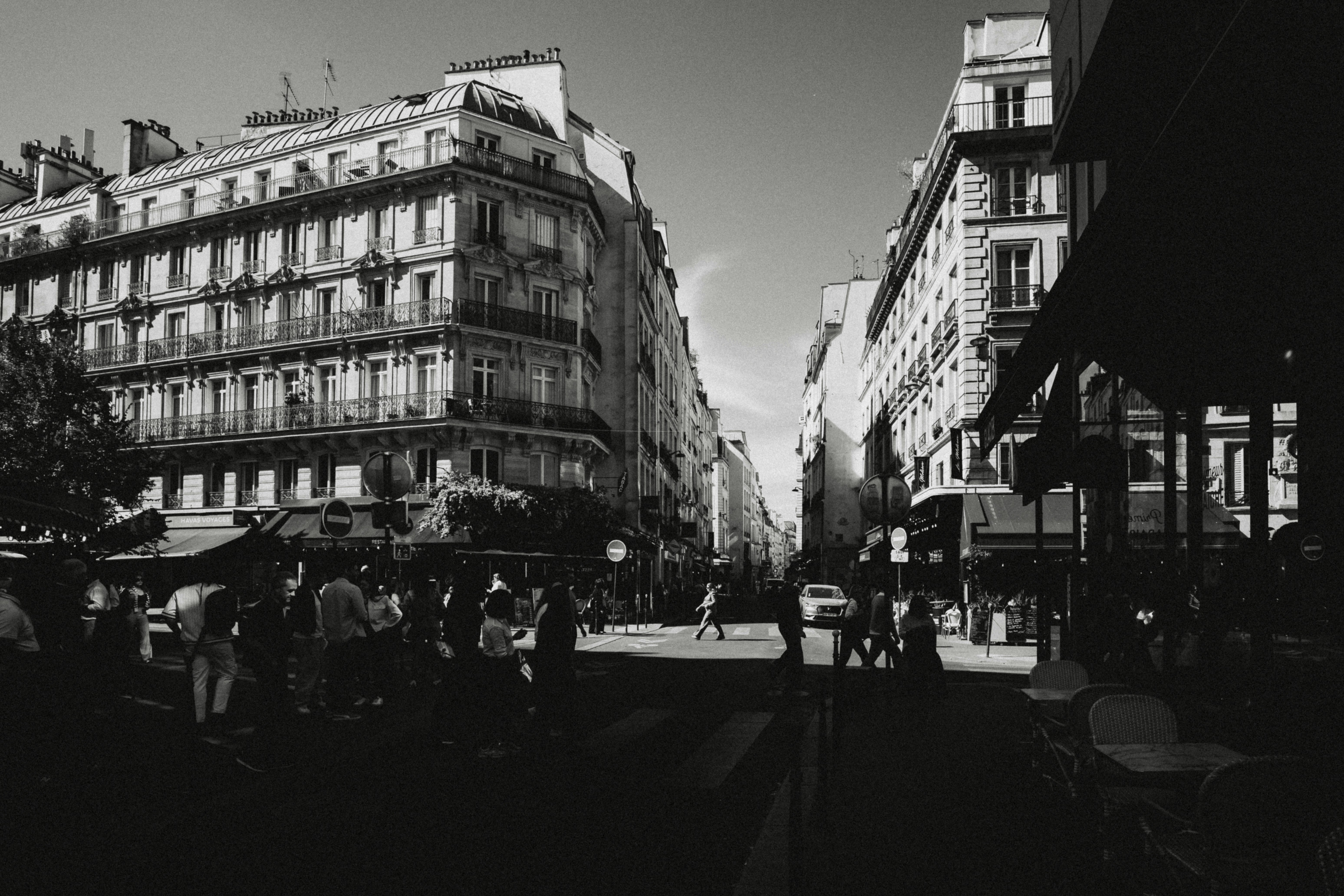 People walking on a street lined with classic Haussmann buildings in Paris
