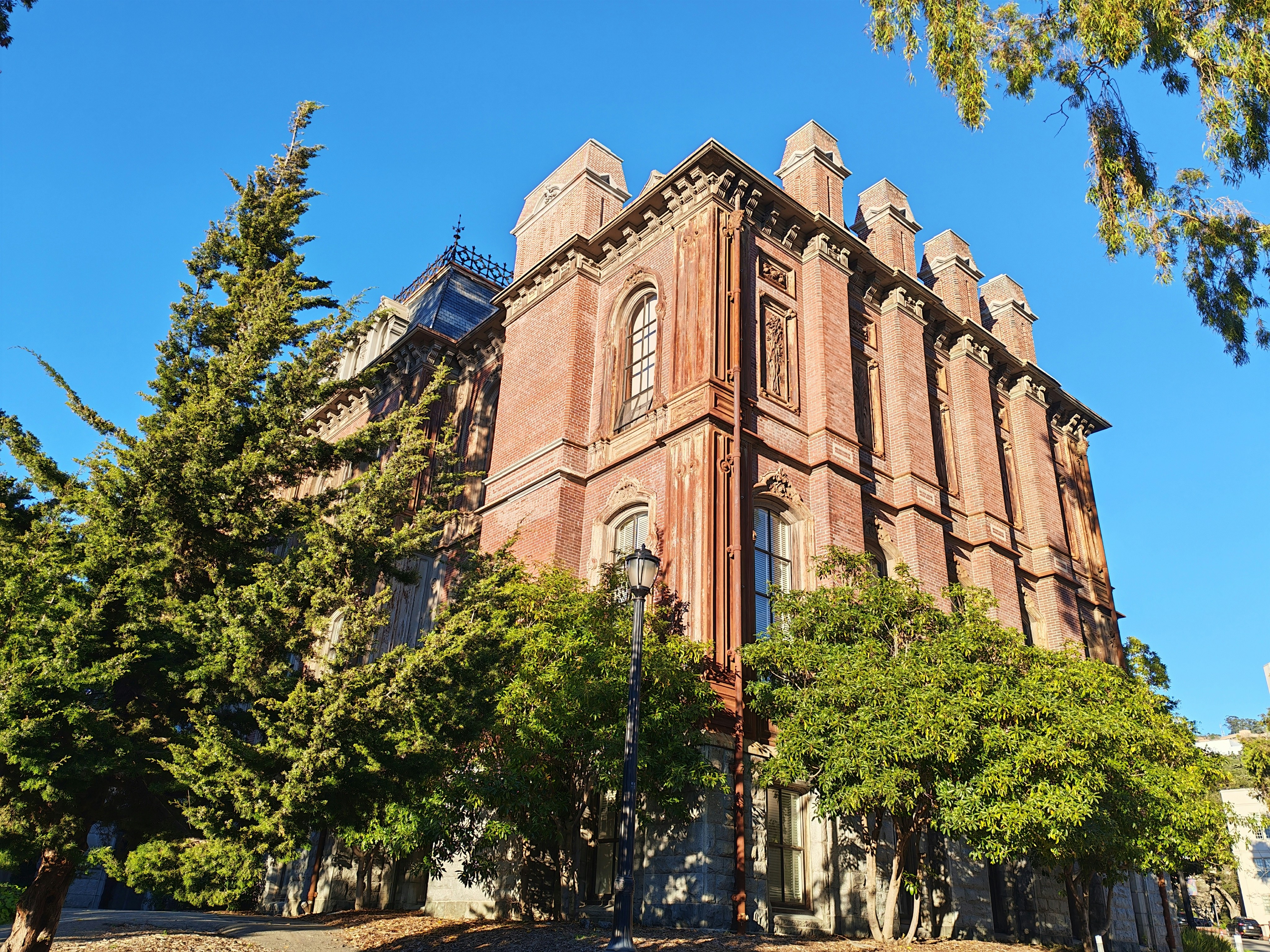 Historic red brick building with trees - Free Photo on Unsplash