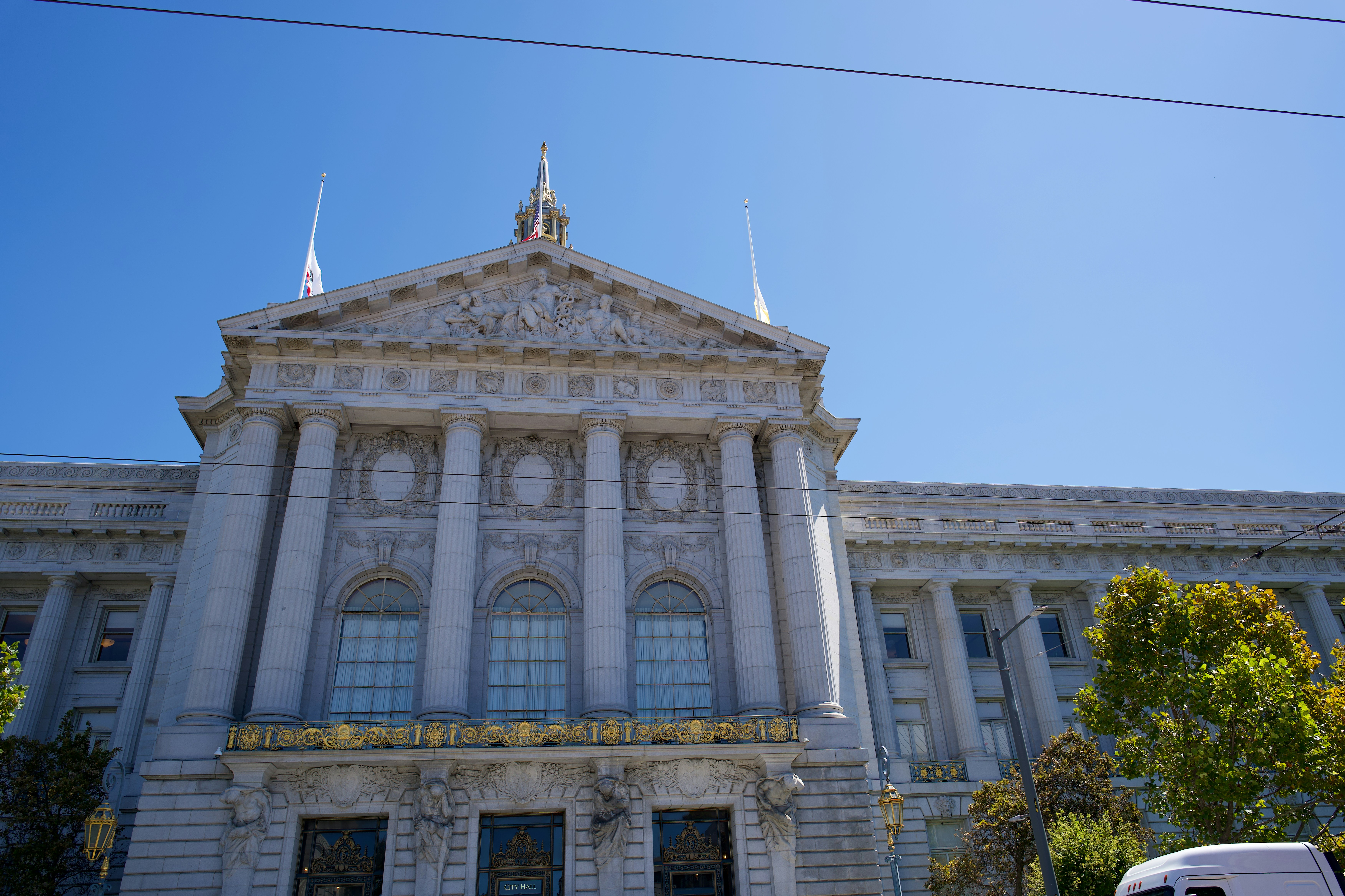 The neoclassical facade of San Francisco City Hall under a clear blue sky
