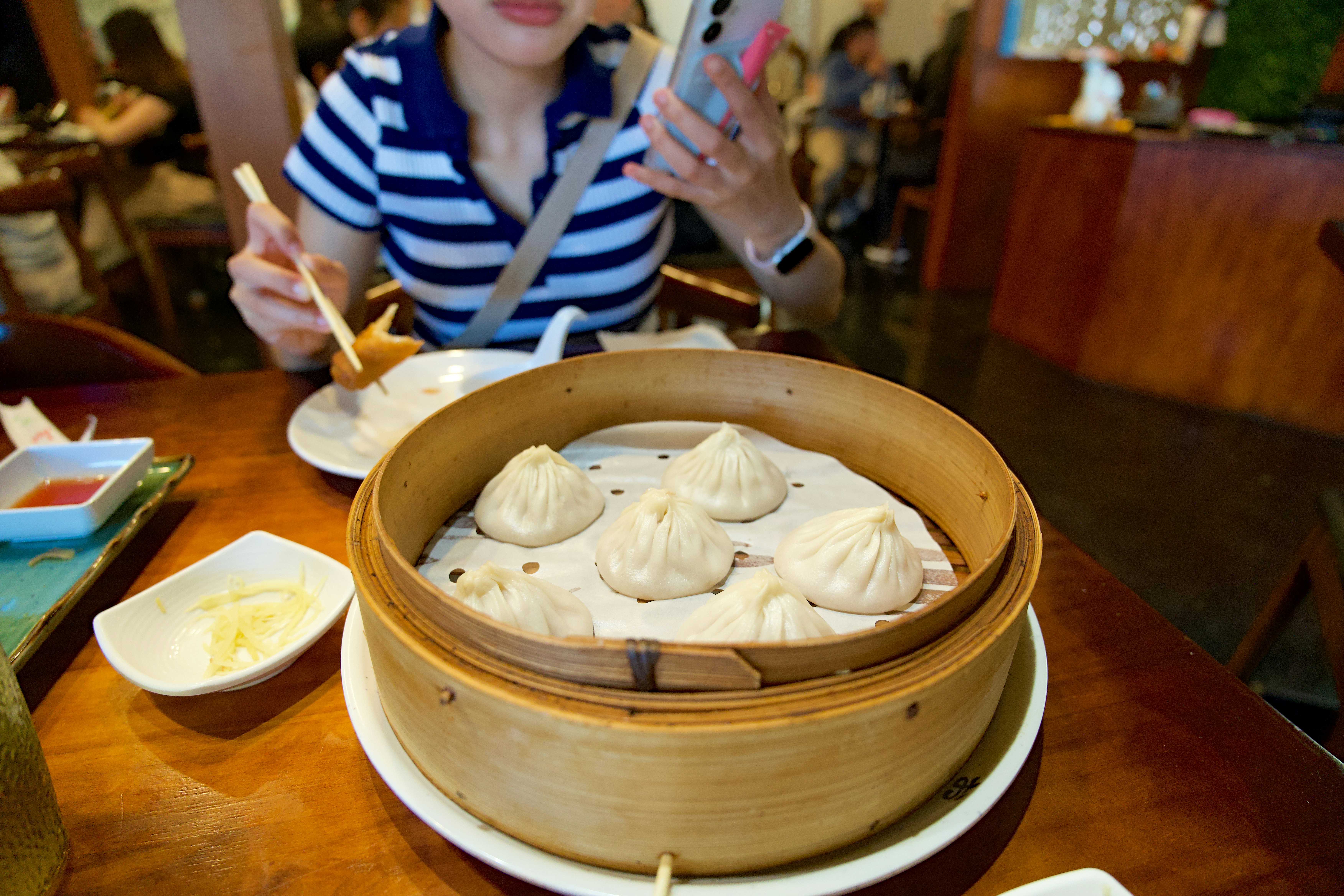 Diner eating soup dumplings from a steamer