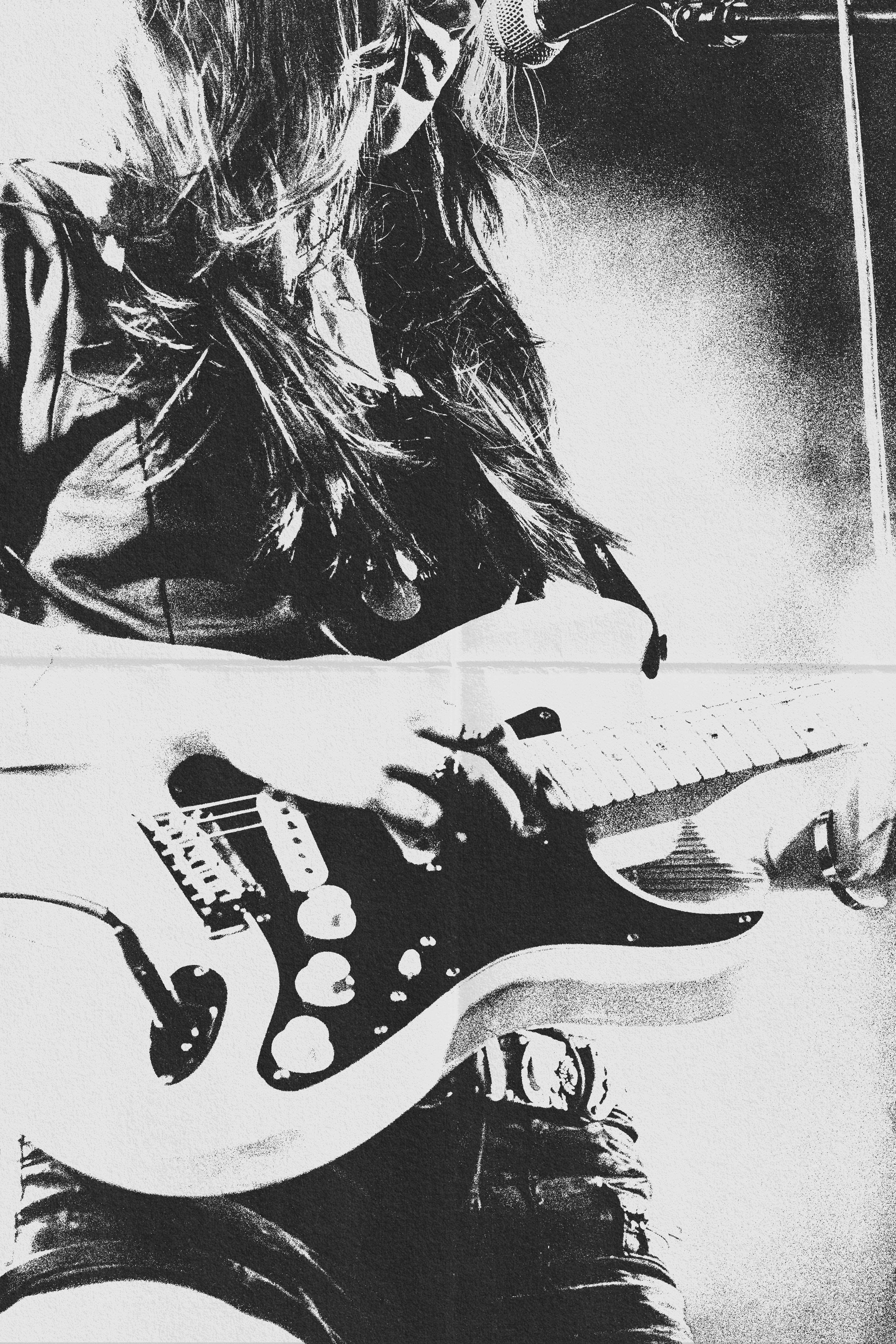A person playing an electric guitar while singing into a microphone on stage