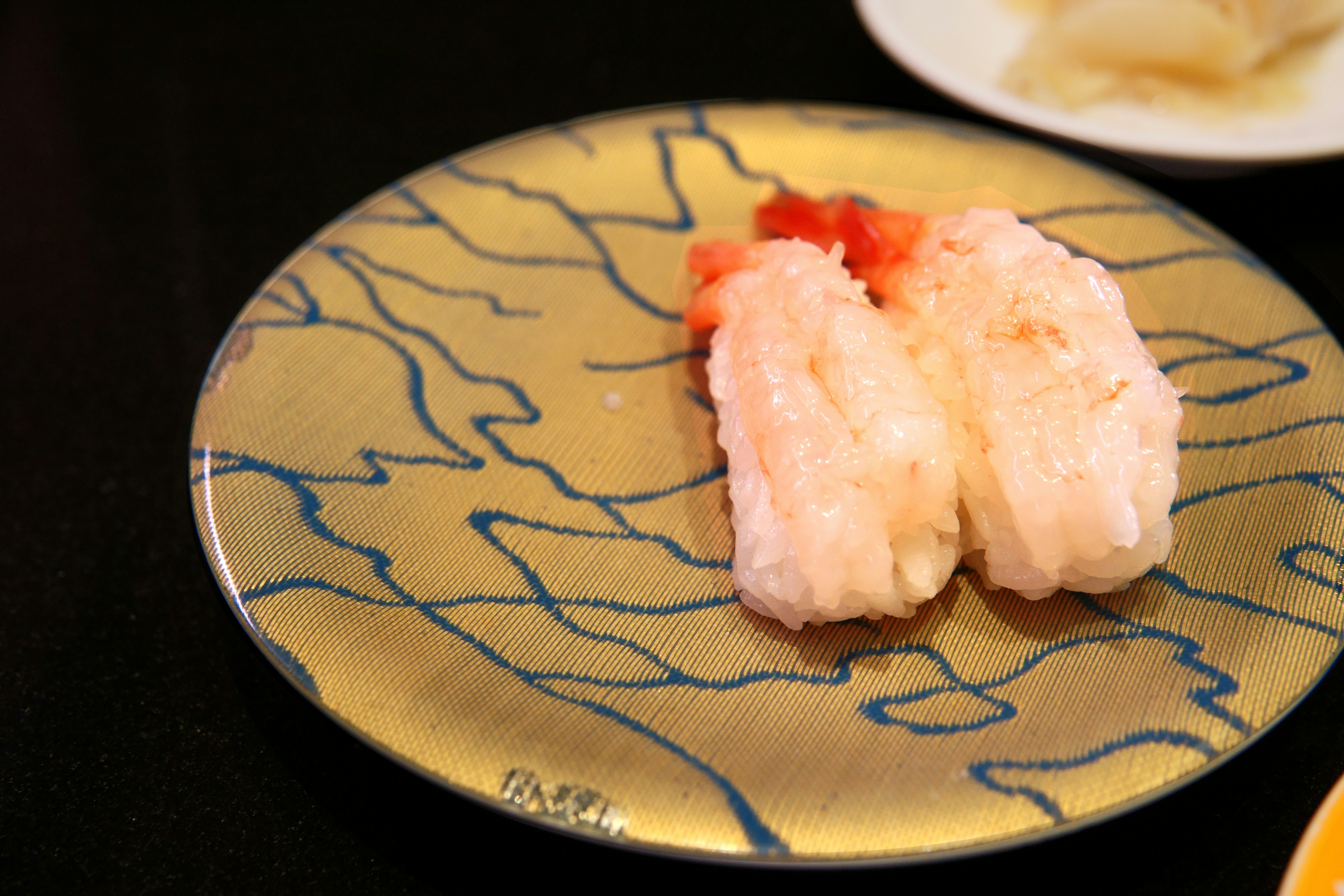 Shrimp nigiri on a patterned plate