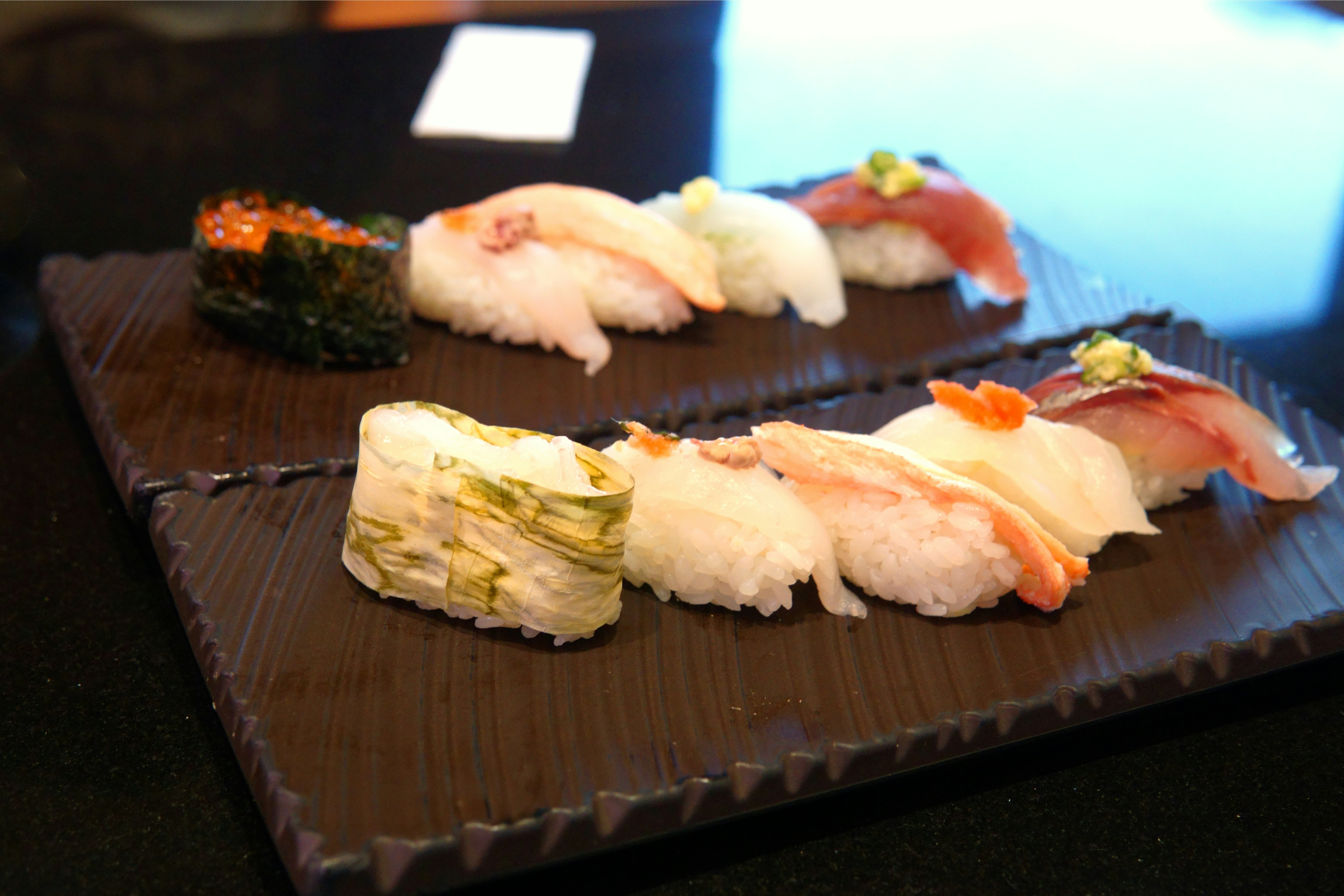 Assorted nigiri on two dark plates