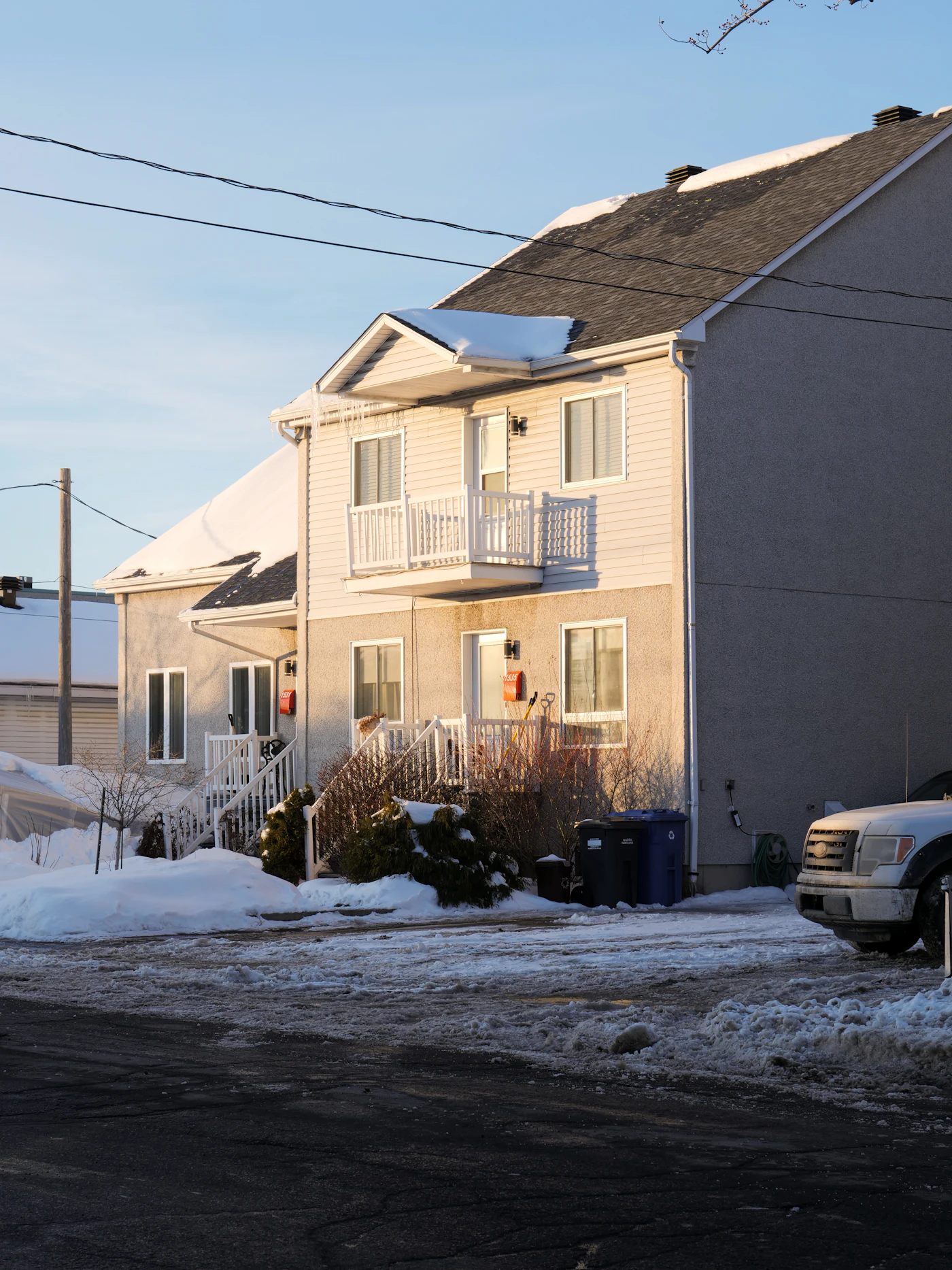 Two-unit house with balconies on a snowy street