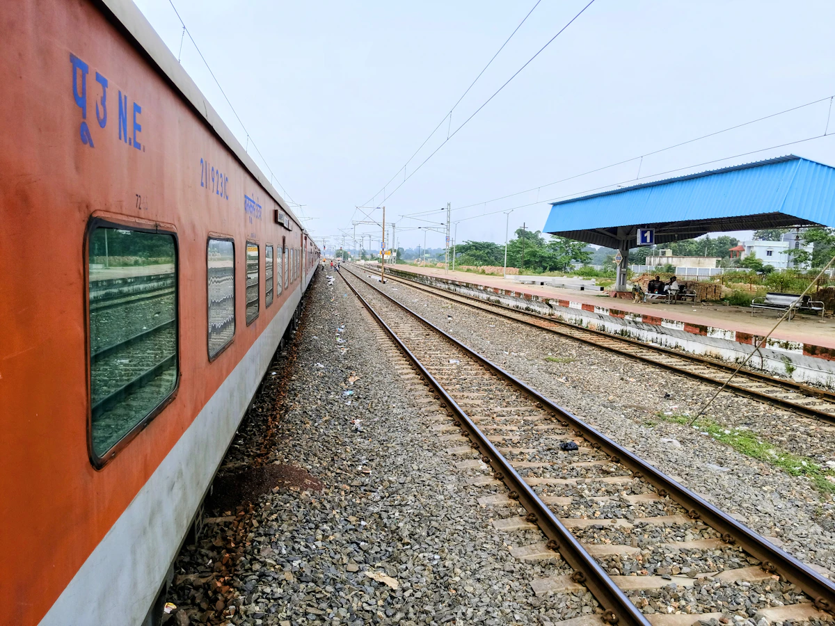 Red passenger train beside a station platform