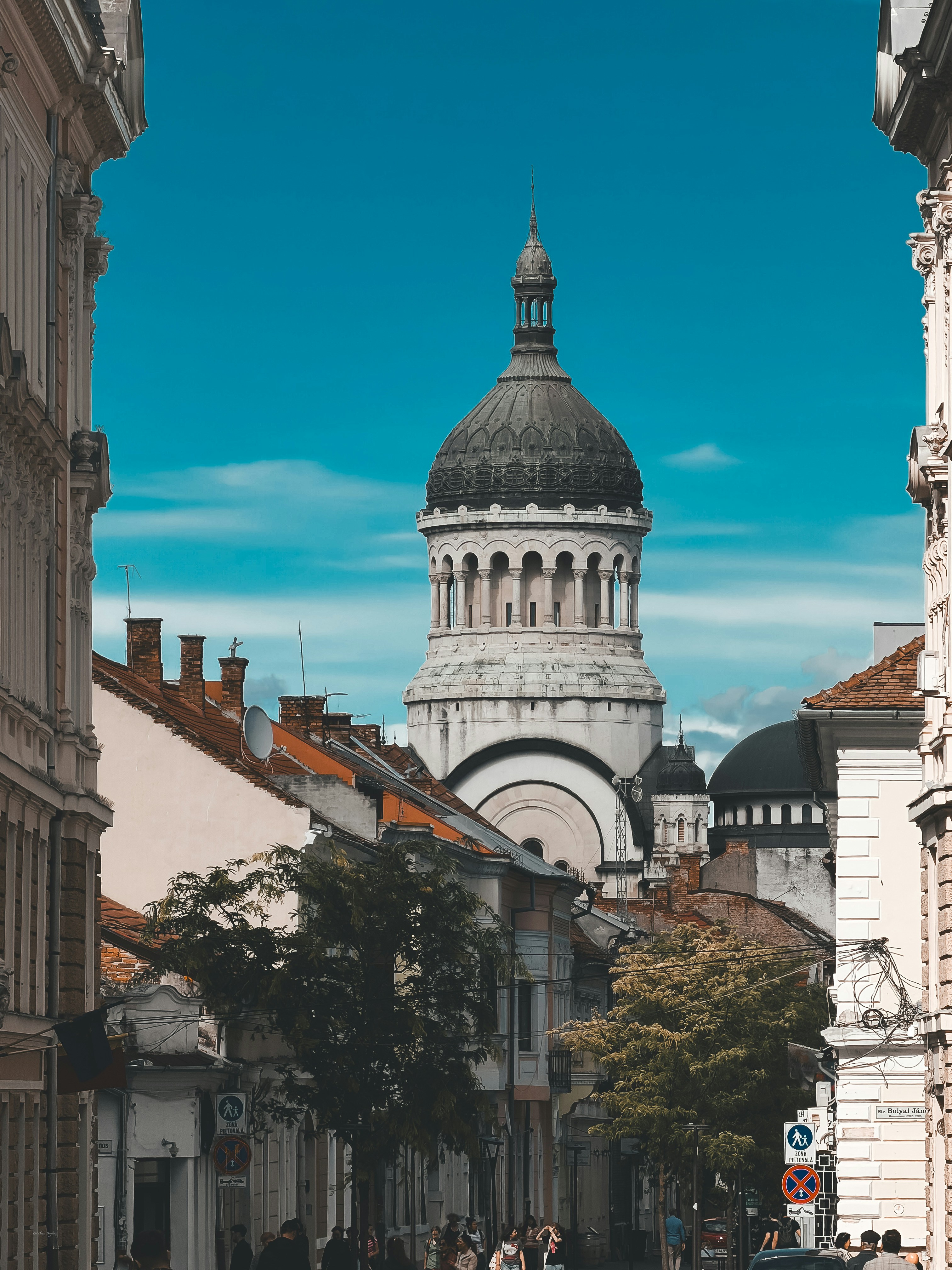 A large stone church dome rising above historic buildings on a city street