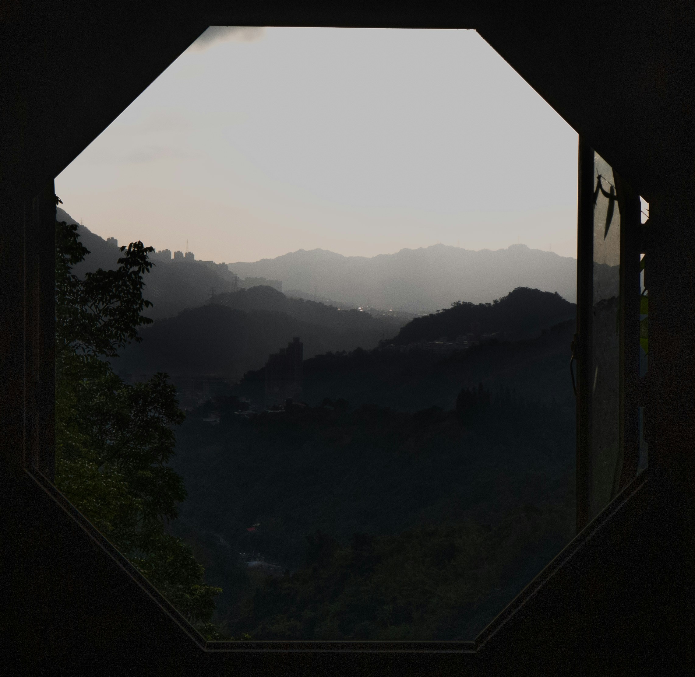 A view of misty mountain silhouettes through an octagonal window frame