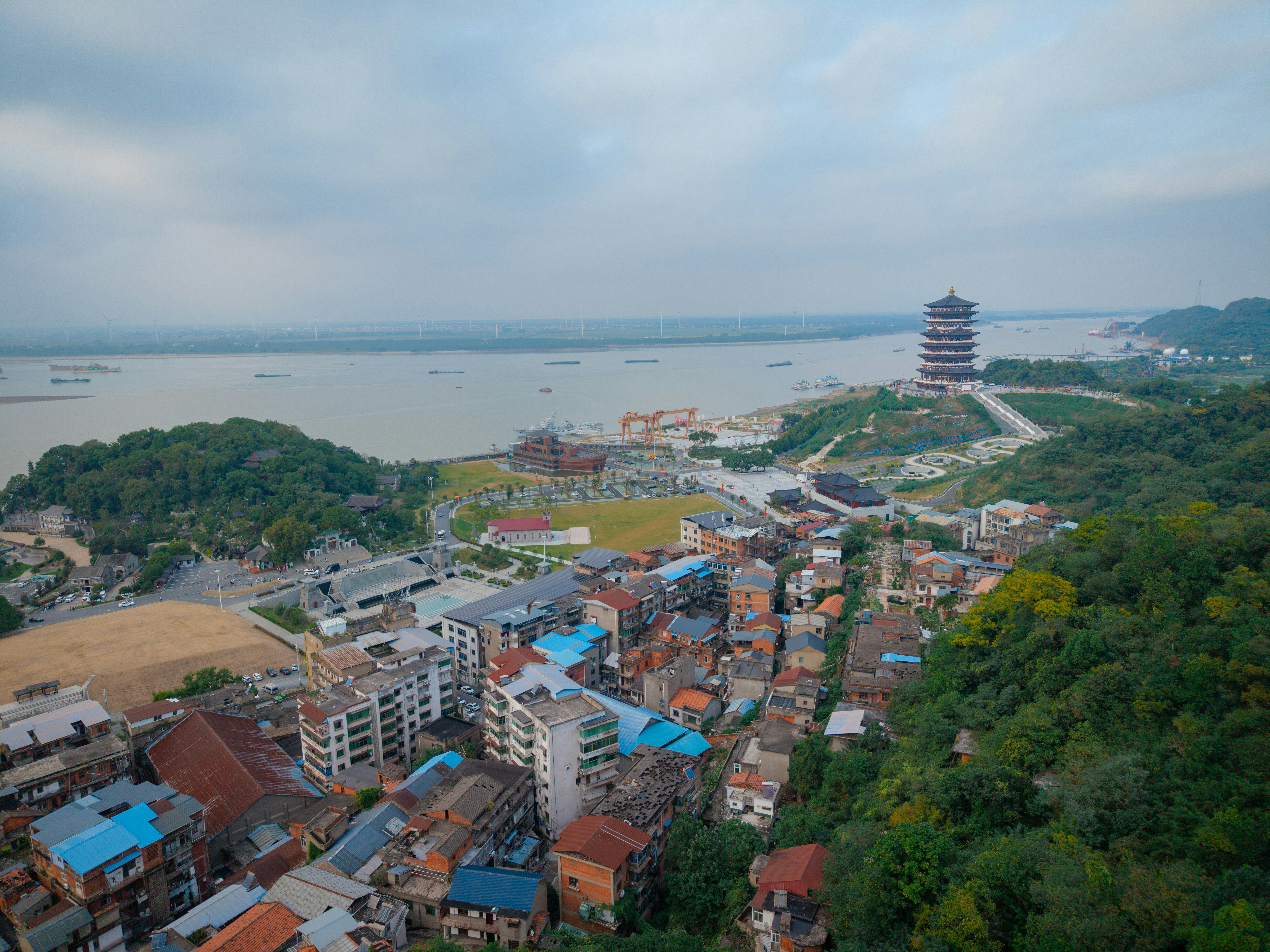 Aerial view of a town with a pagoda overlooking a wide river