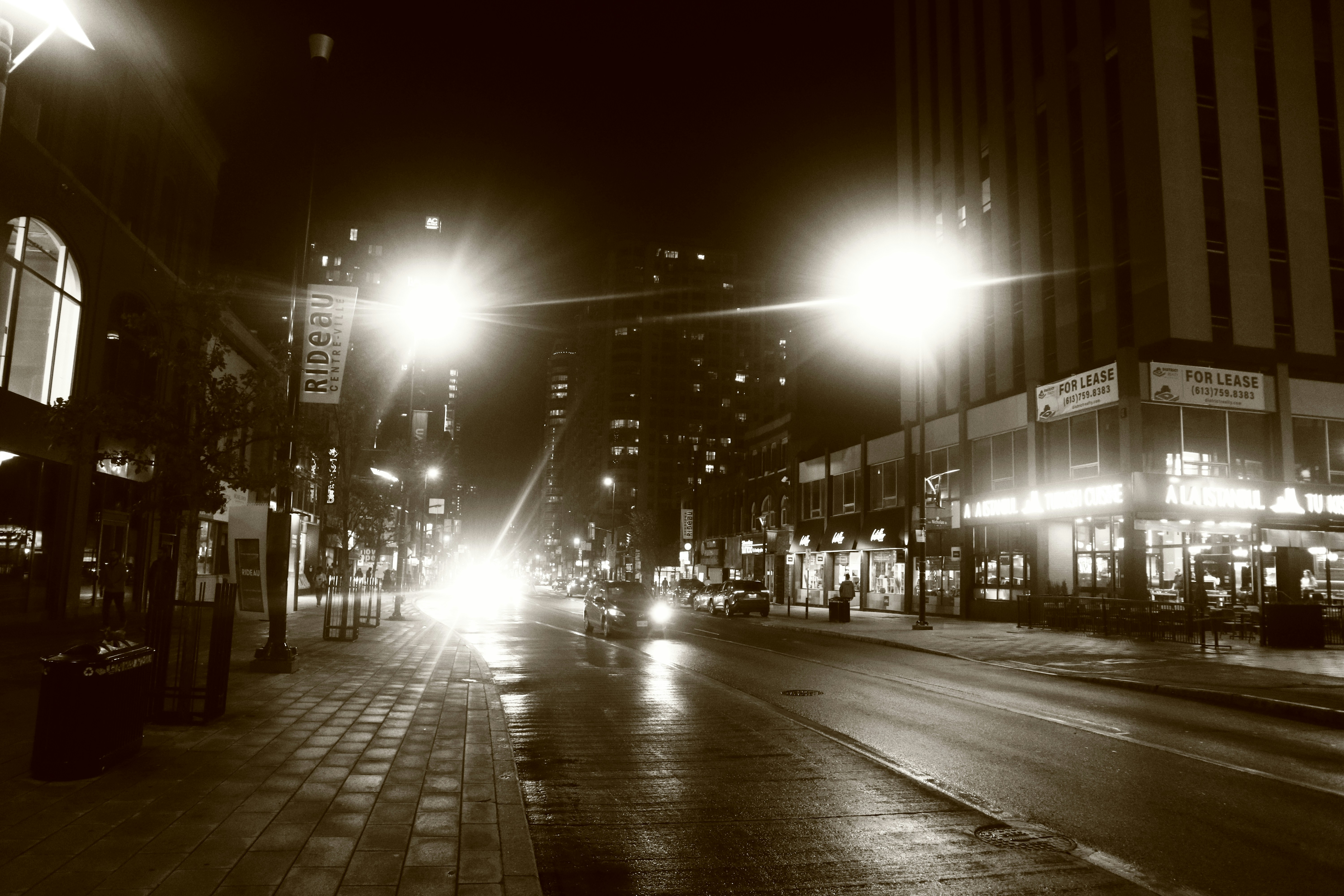 A city street at night with bright streetlights and cars in Ottawa