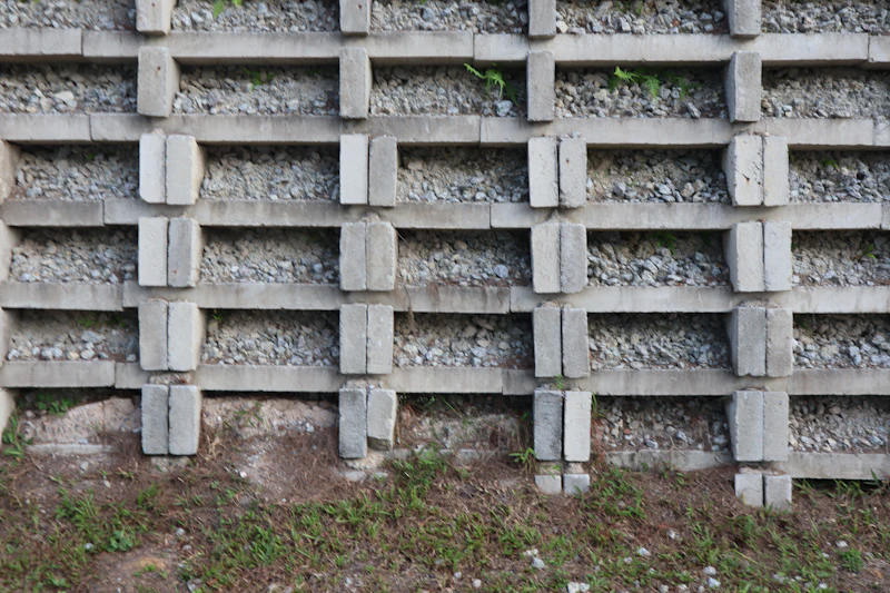 Stacked block retaining wall above a grassy slope