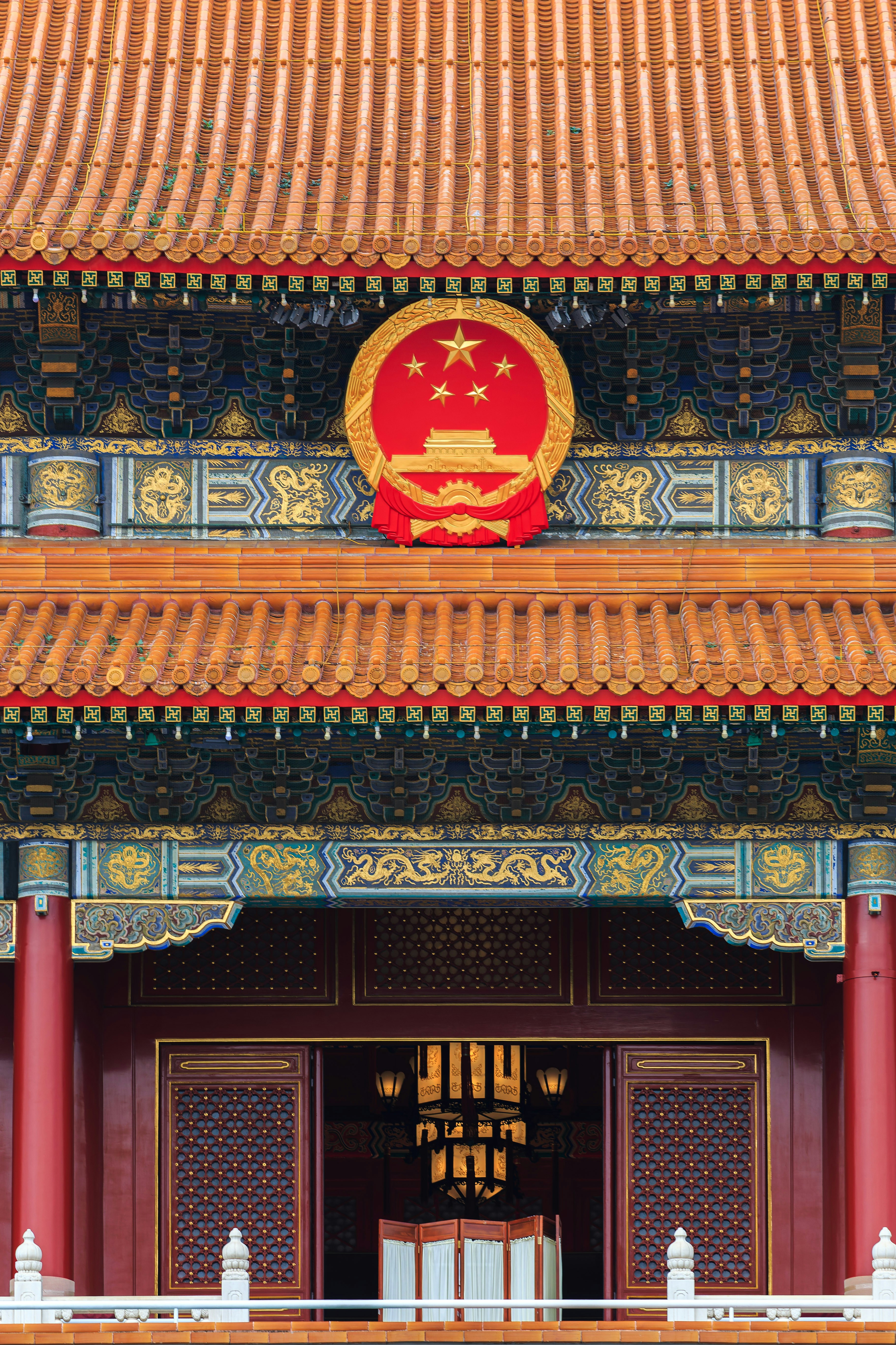 The national emblem of China on the ornate roof of the Forbidden City