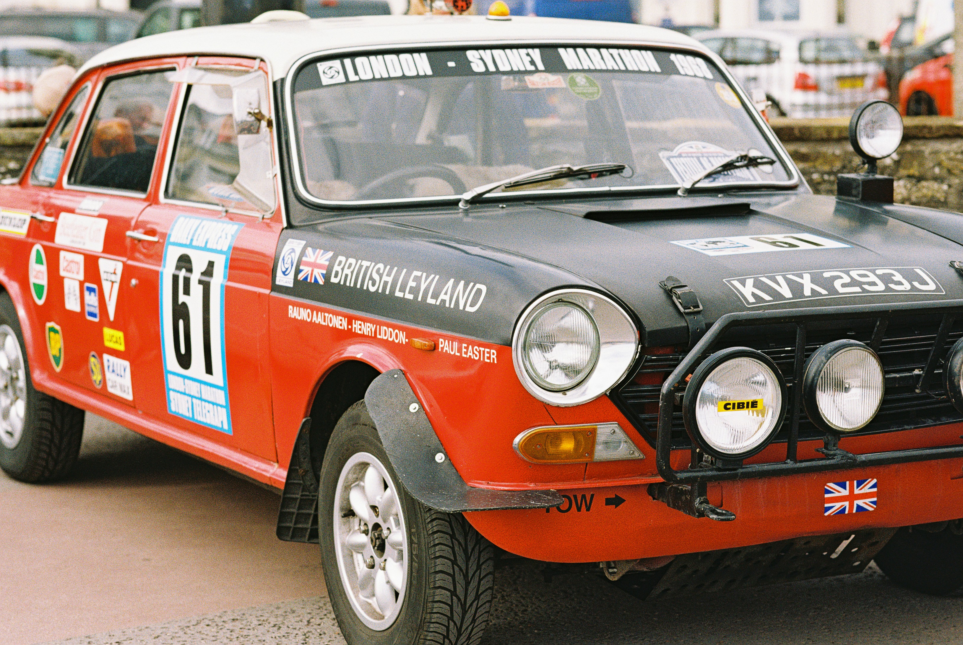 A red and black rally car with racing decals and auxiliary lights