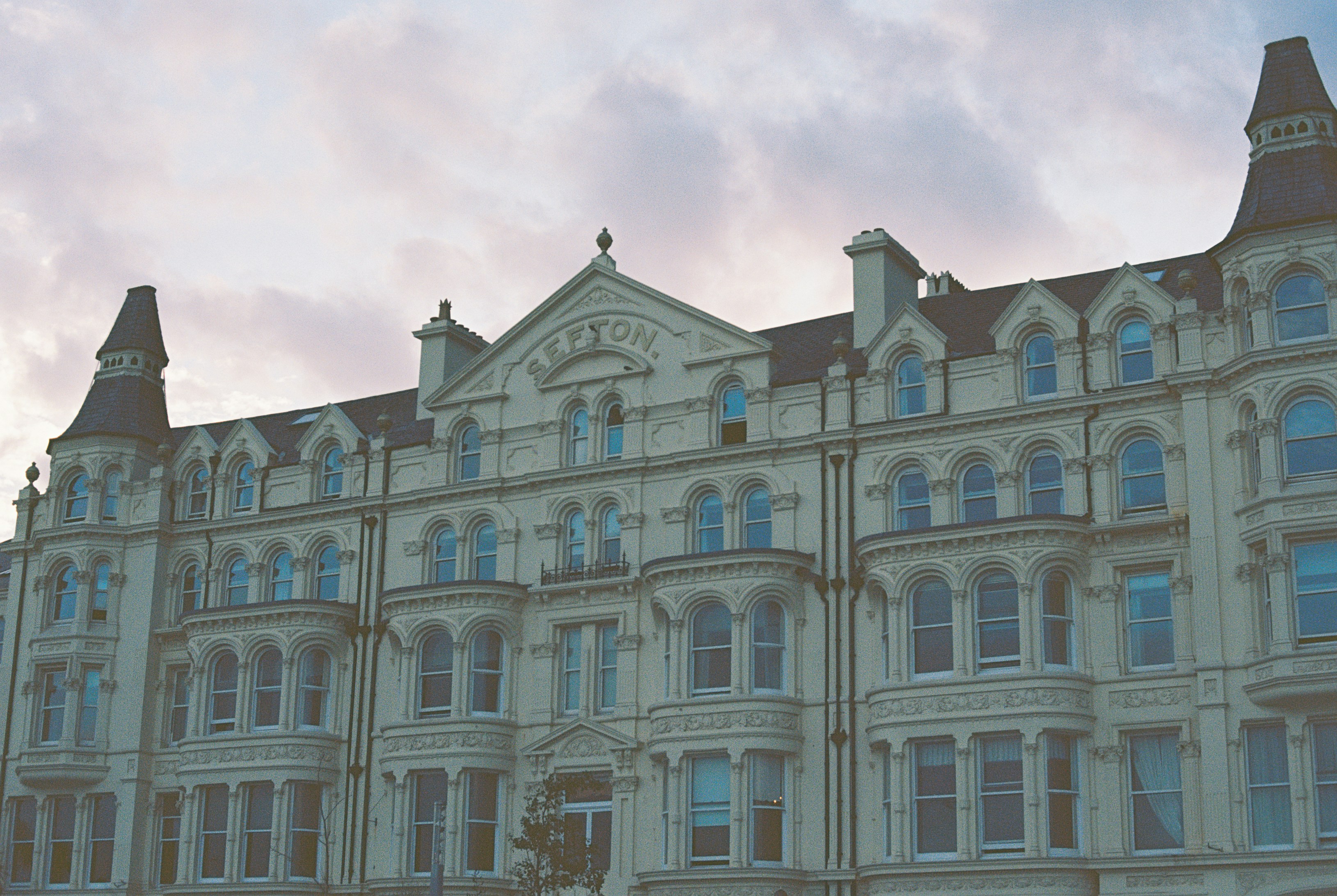 The Sefton hotel building with ornate cream facade and turrets under a cloudy sky
